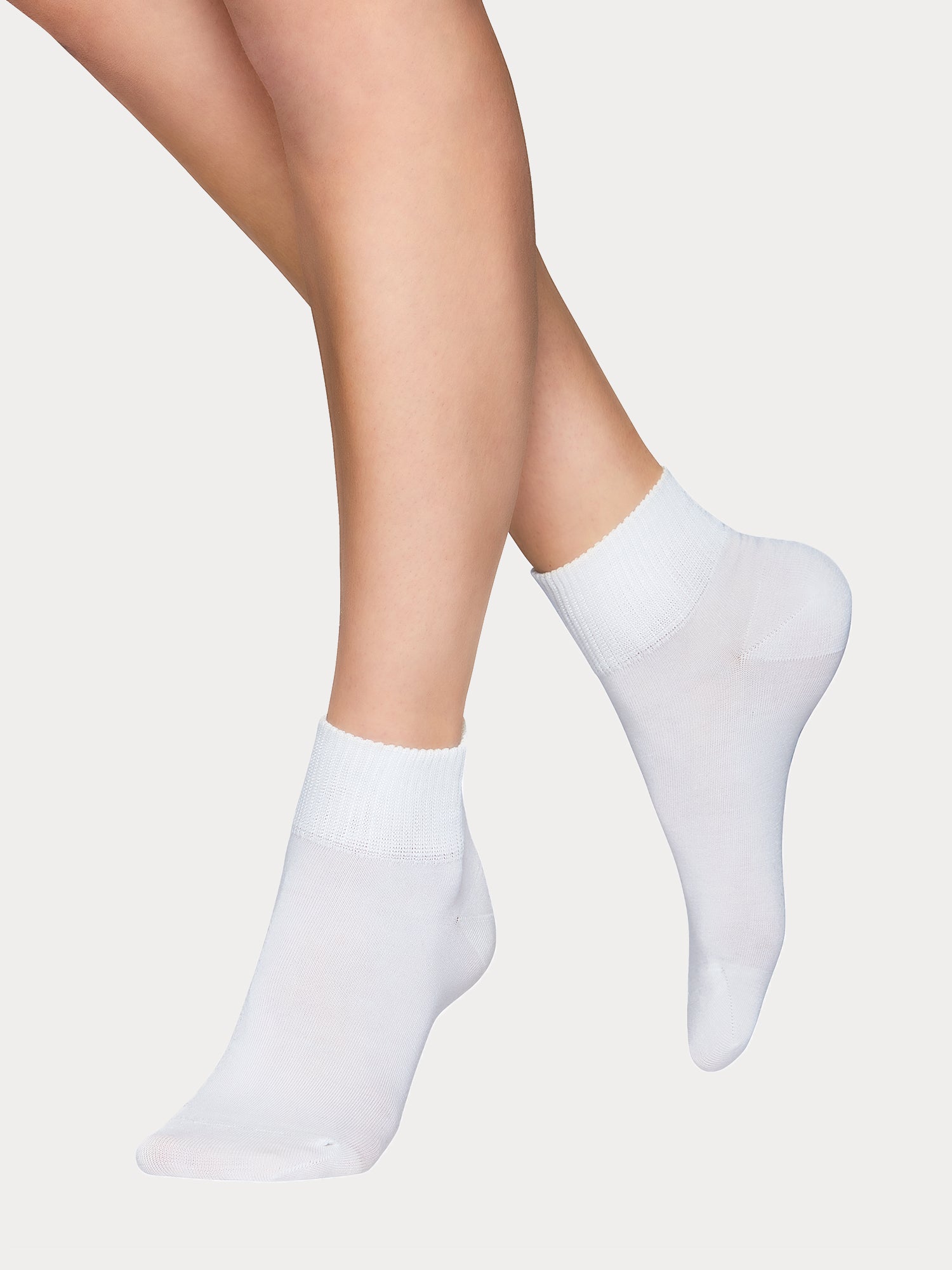 Vogue women's Lyocell Sneaker socks are crafted from sustainable lyocell. The contemporary wide cuff provides a secure, comfortable fit. White pair of socks pictured on a model.