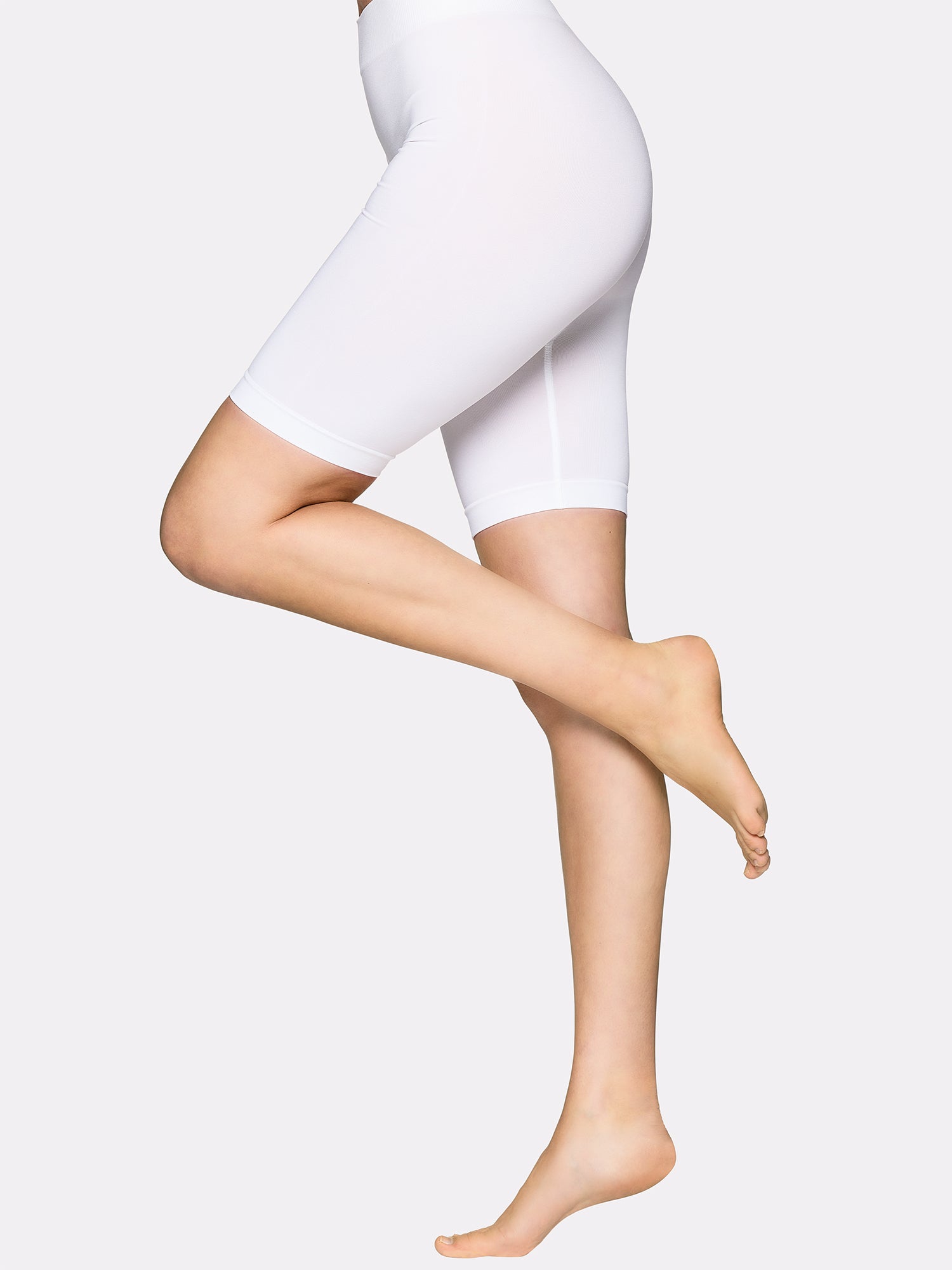 Vogue's soft and comfortable in white short leggings made of smooth microfiber from left on model.