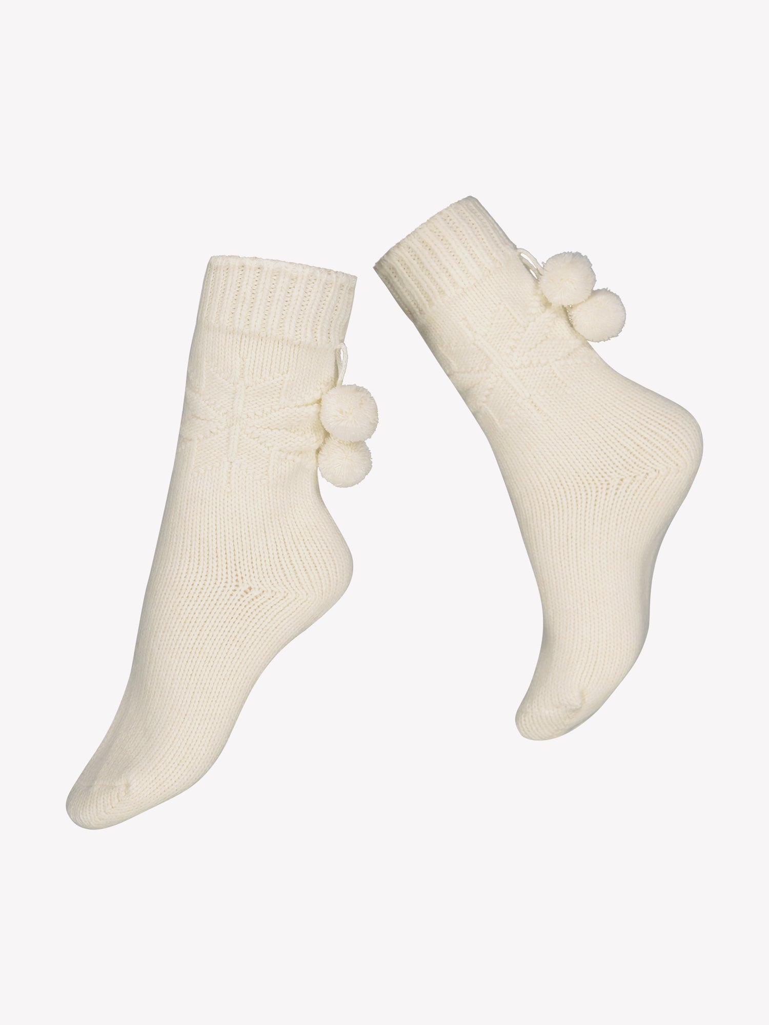 Vogue's wool blend socks in a off-white color with snowflake pattern on the ankle and pompoms placed in a product picture.
