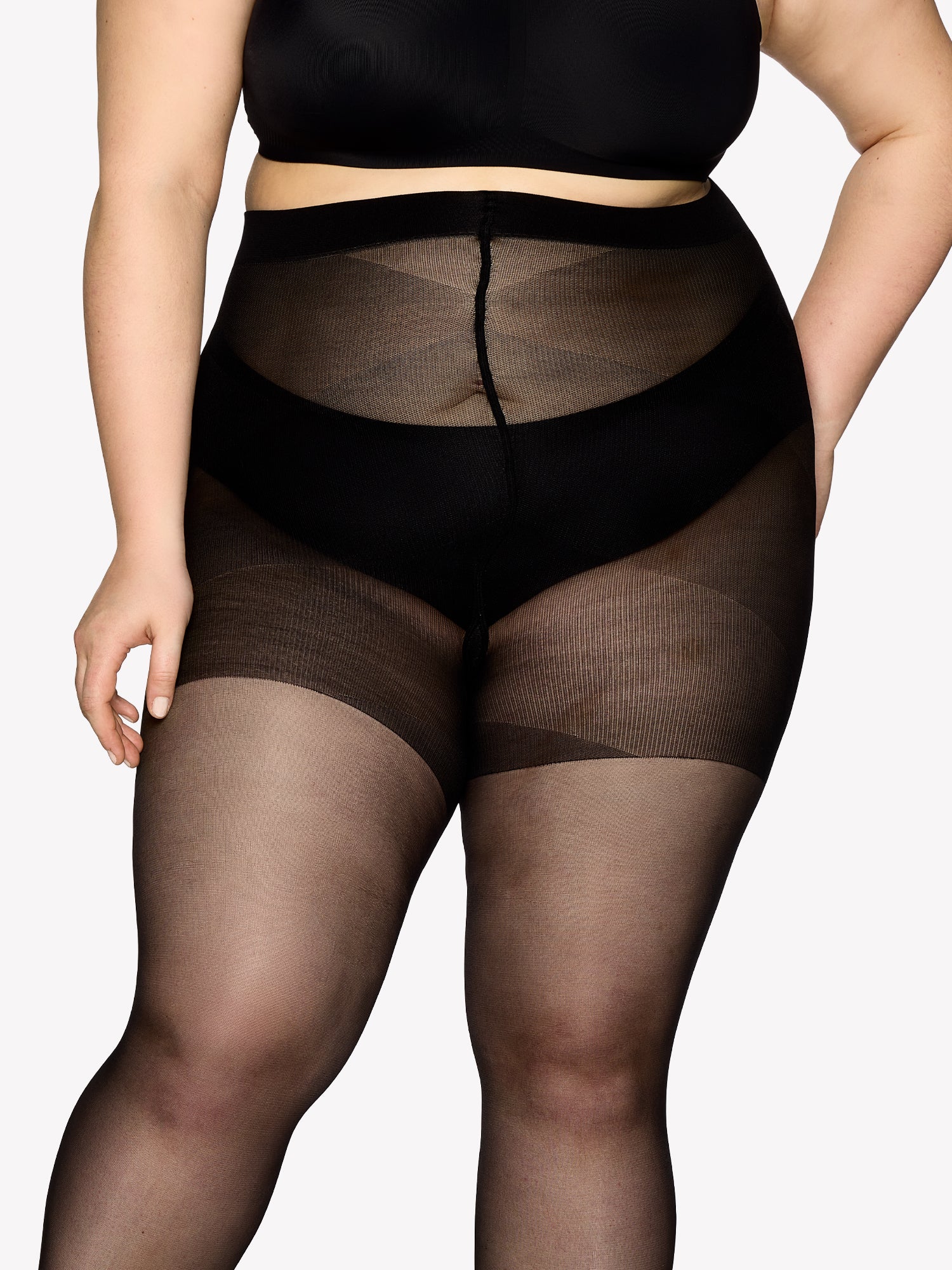 Vogue women's Curvy 40 denier sheer semi-matte tights, expertly crafted for curvy figures with elastic waistband and a light panty part without panel gusset. On a model in shade black from the front, close-up.