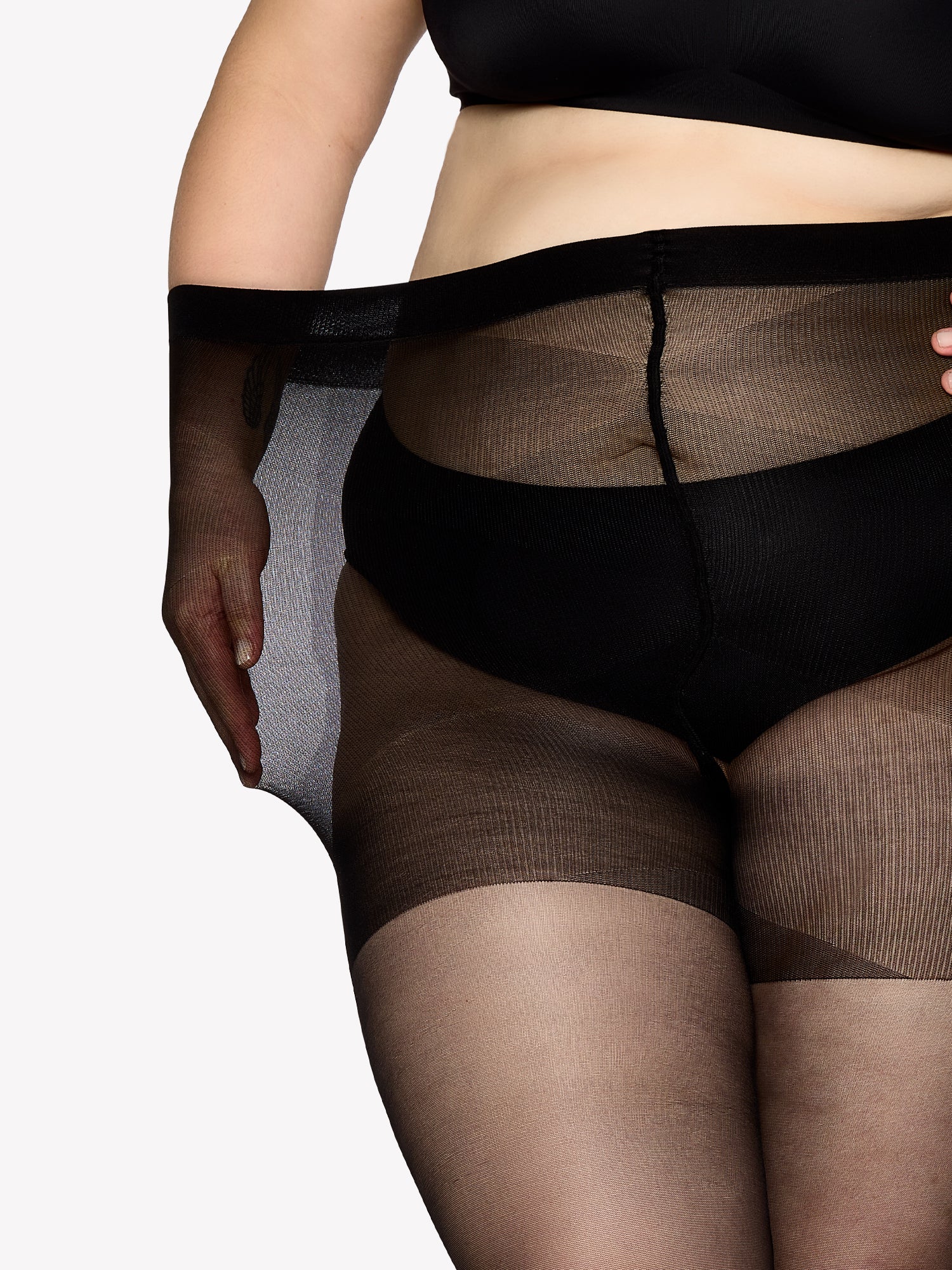 Vogue women's Curvy 40 denier sheer semi-matte tights, expertly crafted for curvy figures with elastic waistband and a light panty part without panel gusset. On a model in shade black, close-up.