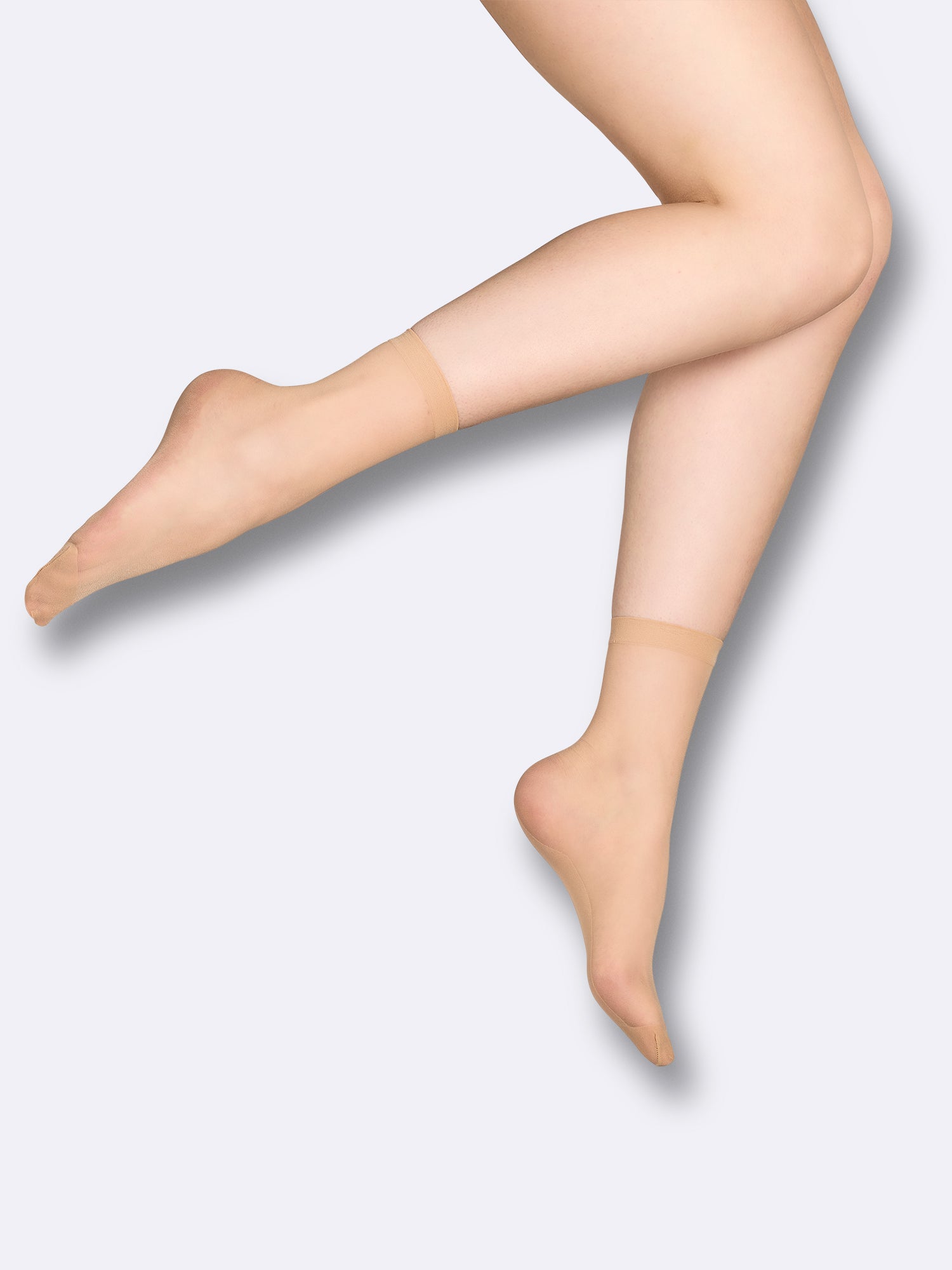 Vogue 20 denier ankle socks in shade Powder feature a semi-matte finish. Reinforced construction at the toe, sole, and heel ensures long-lasting wear. on a model pictured from the side.