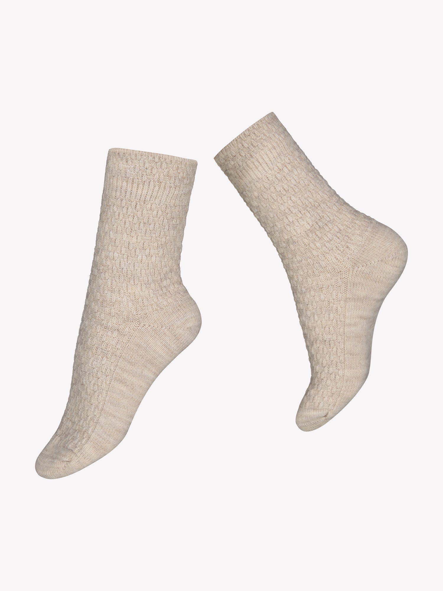 Vogue's Carina wool blend socks in beige with cable knit pattern in a product picture.