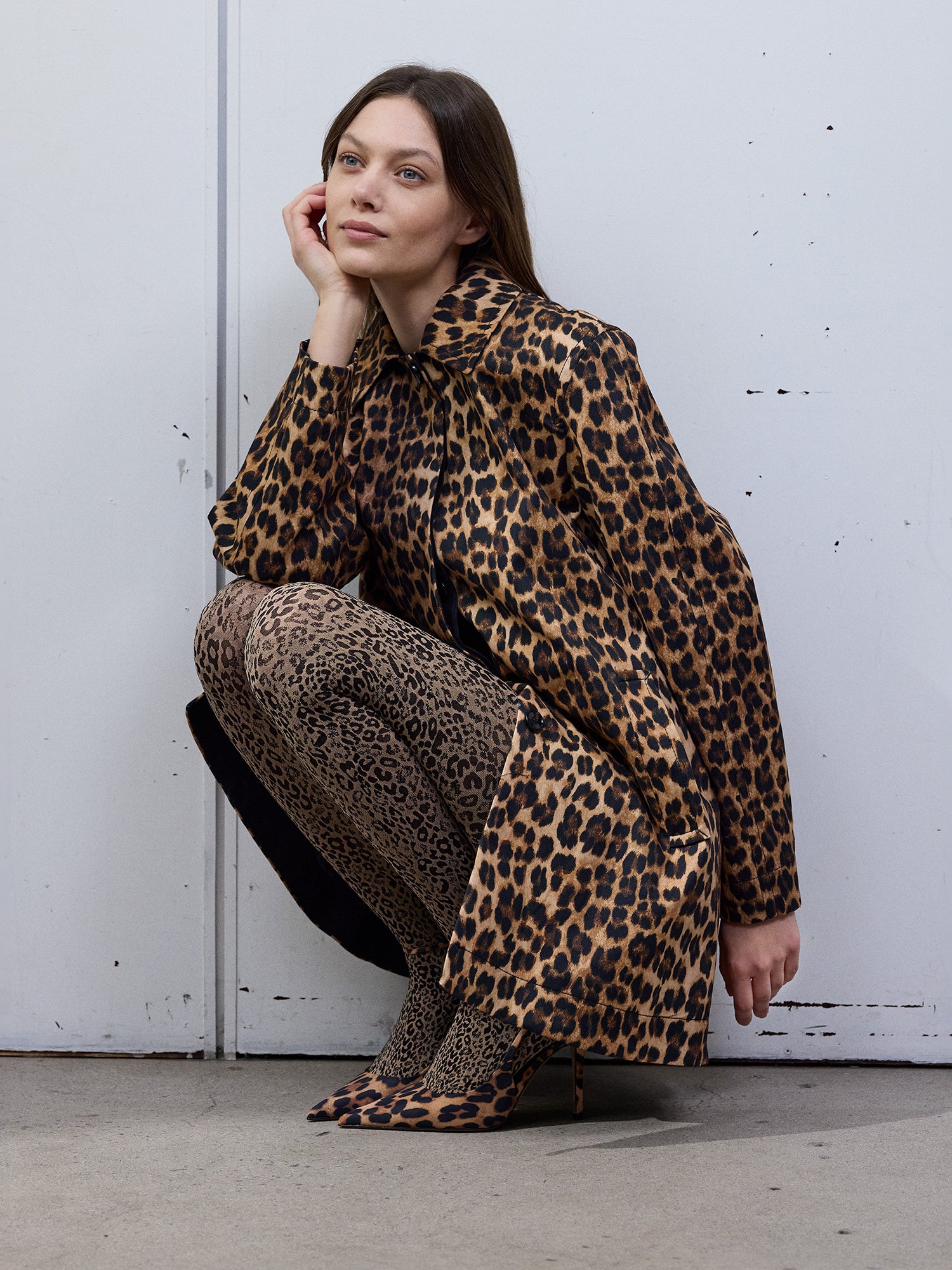 Vogue’s Gina tights with beige and black leopard print worn by a model from the front view. The tights are styled with matching leopard print shoes and dress.