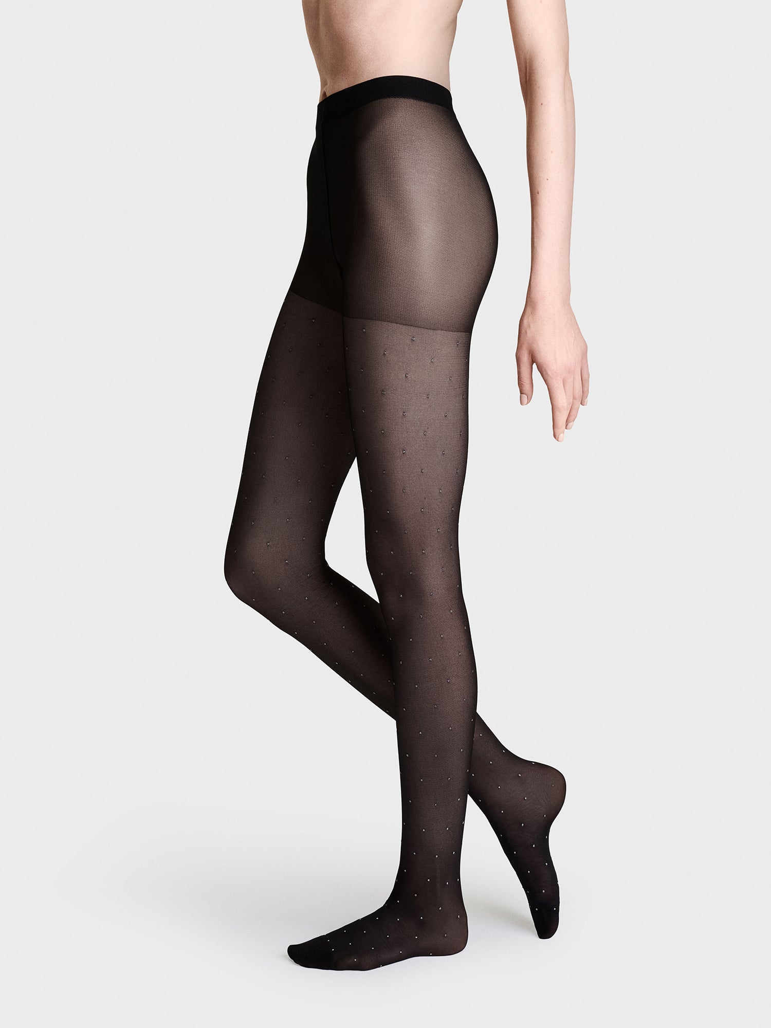 Vogue 30 denier tights with a beautiful printed silver dot pattern. These high-class tights feature a delicate, shimmering dot pattern on a natural, matte surface. Pictured on a model
