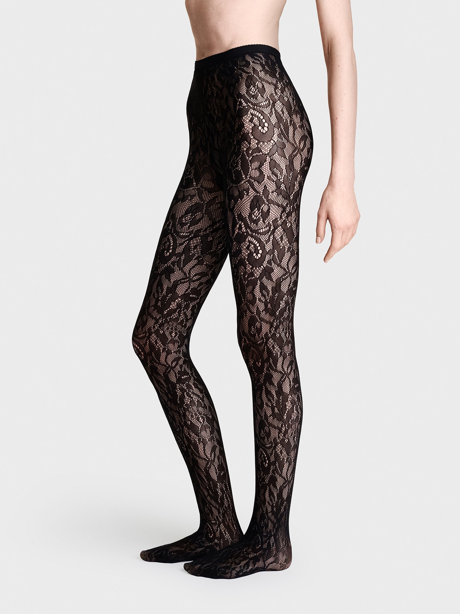 Vogue's beautiful 30 denier floral lace tights in black, on a model