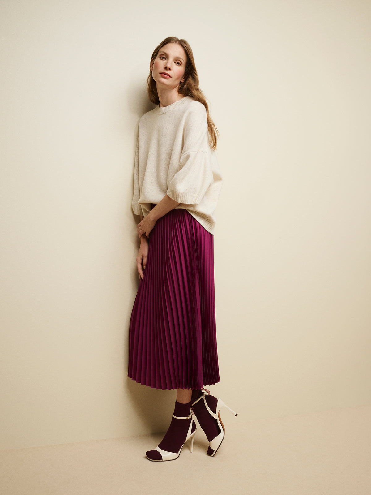 Nanso's elegant Taite skirt for women features a graceful drape in a vibrant violet shade, on a model with a white half-sleeved sweater. | 36 - 175,5cm