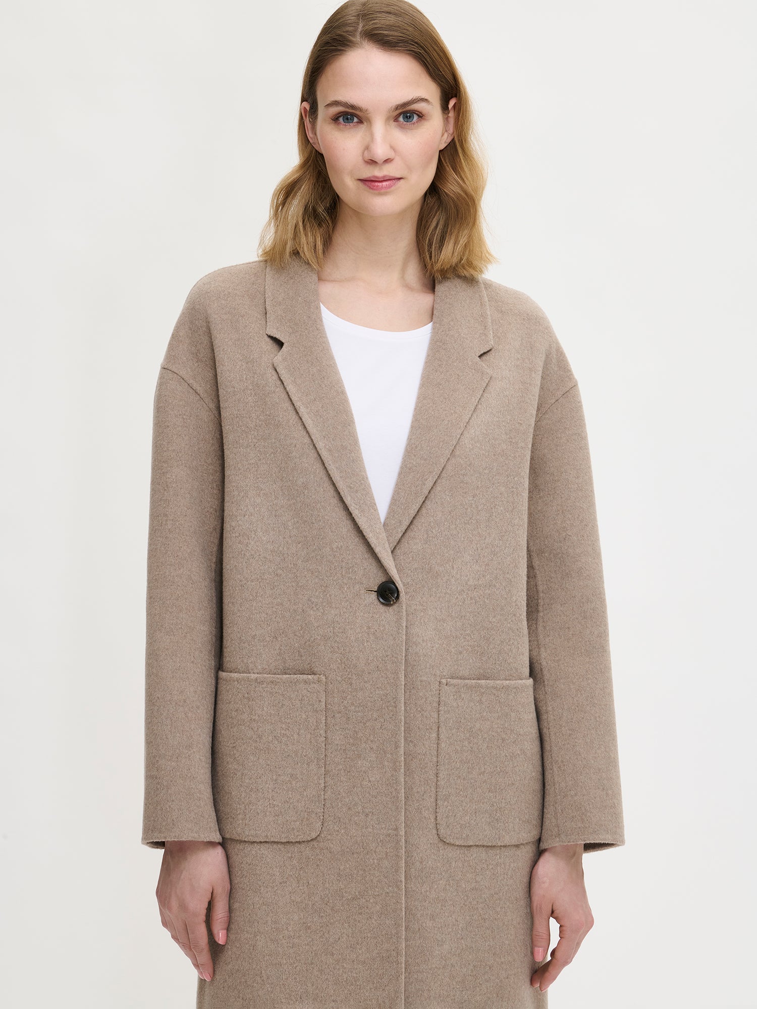 Nanso women's stylish and timeless beige YLLE wool coat. On a model from the front, close-up