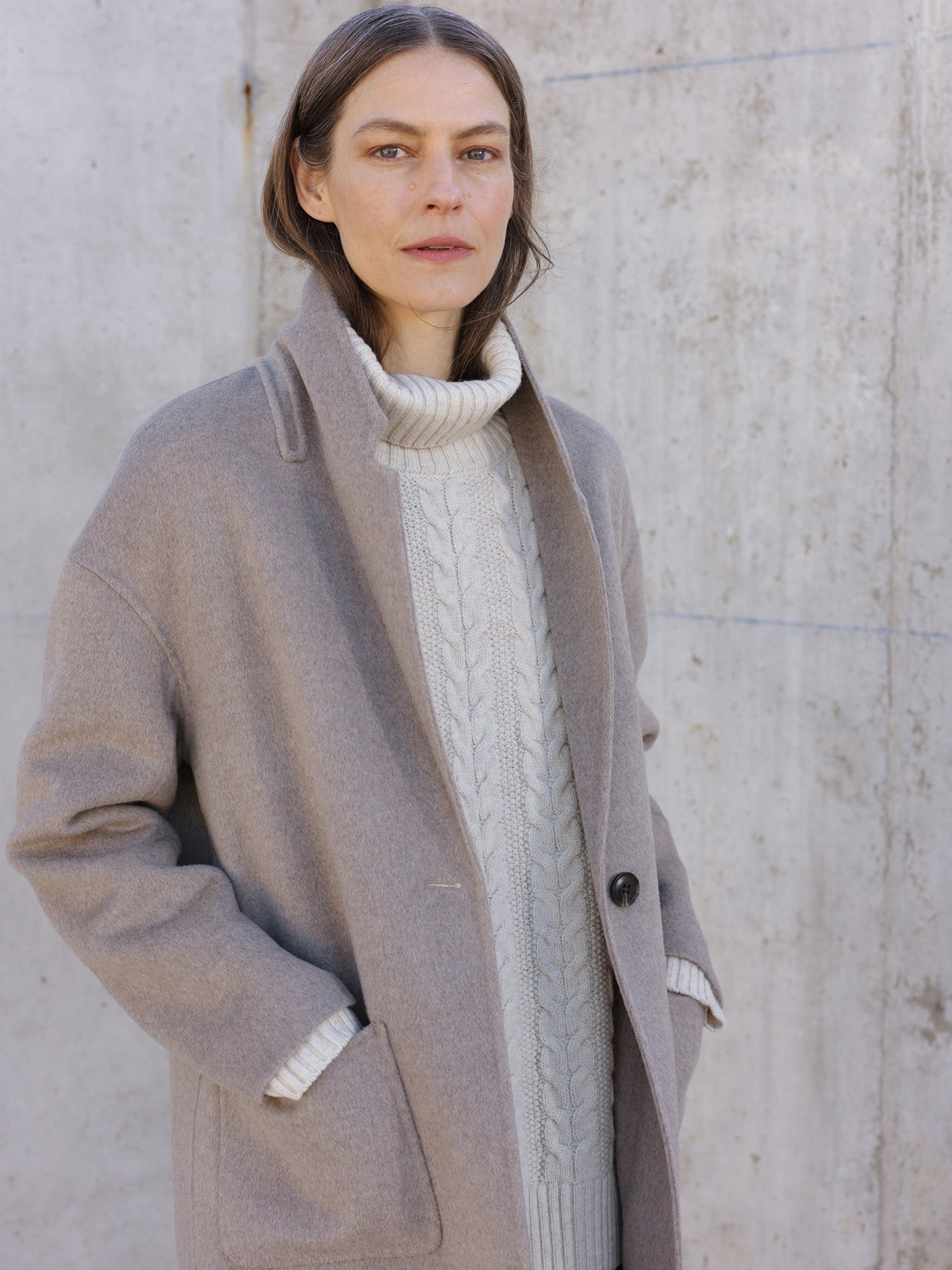 Nanso women's stylish and timeless beige YLLE wool coat. On a model from the front with knitted shirt