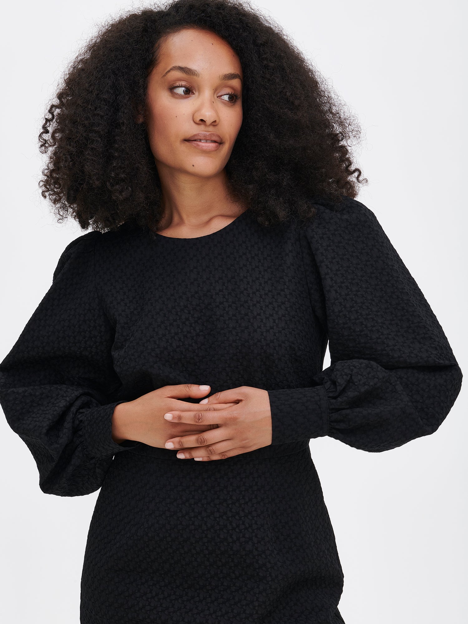 Nanso's elegant black Reliefi dress. On a model in size 36, front close-up