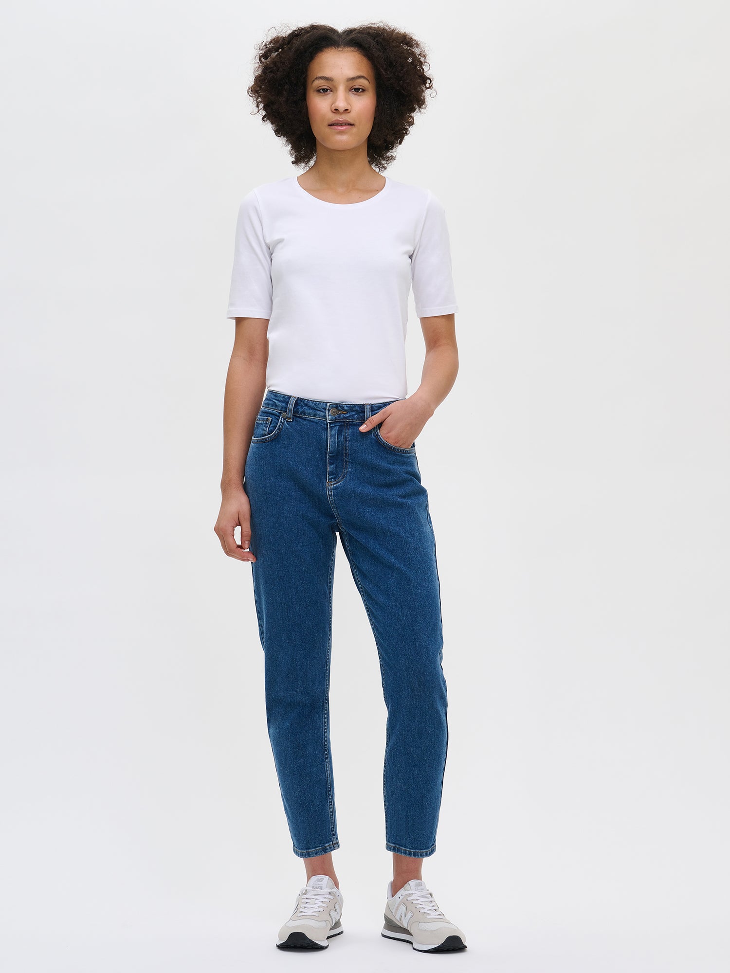 Nanso women’s comfortable, cropped and trendy blue Fiilis jeans from the front on the model. Paired with a white Nanso T-shirt.