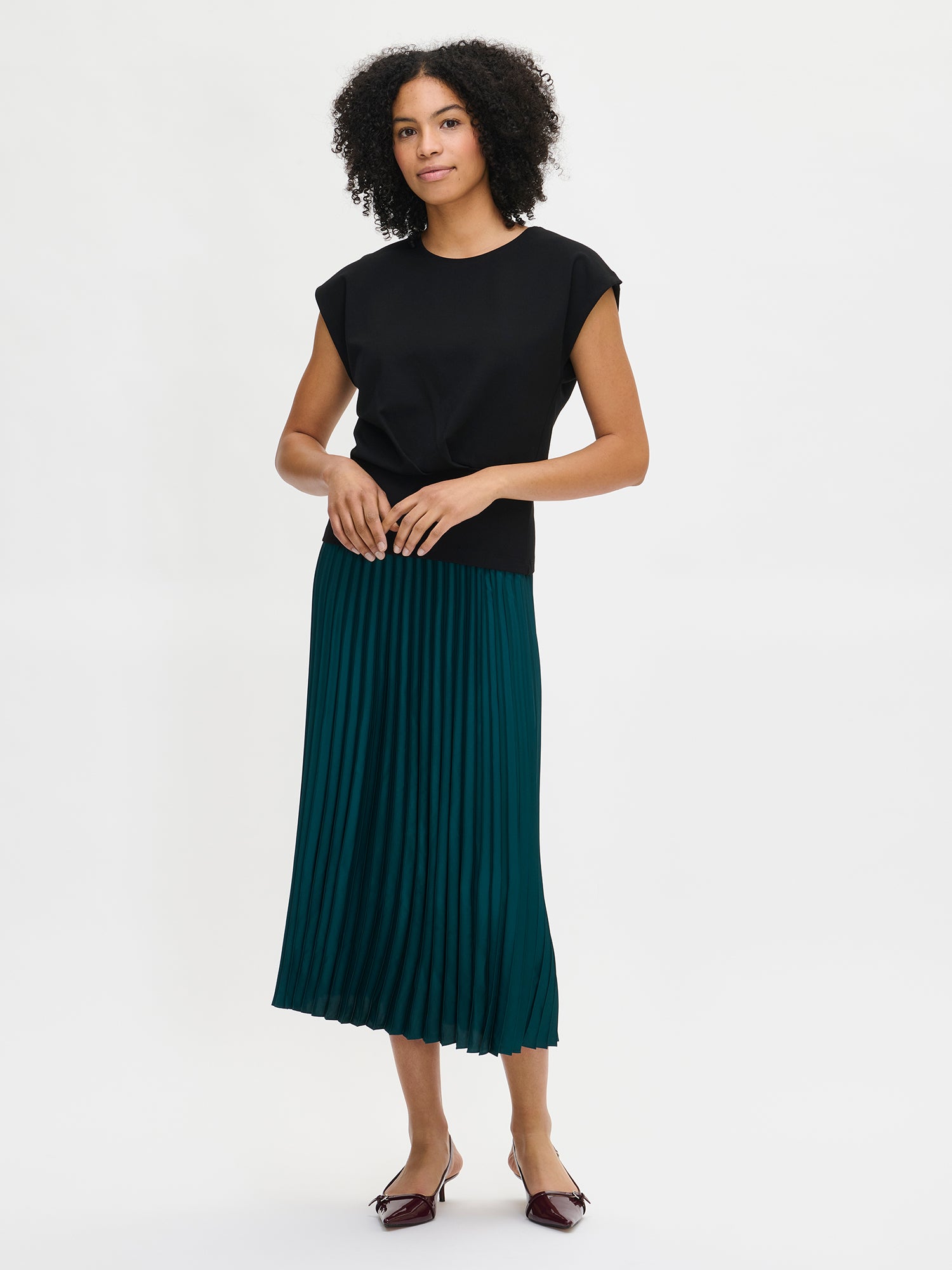 Nanso's elegant Taite skirt for women features a graceful drape in green shade, on a model