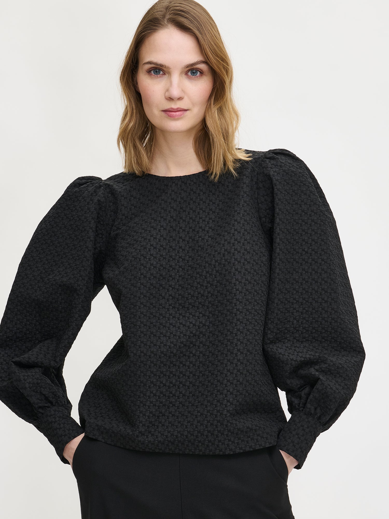 Nanso's stylish women's blouse in black features a beautiful textured surface. From the front close-up