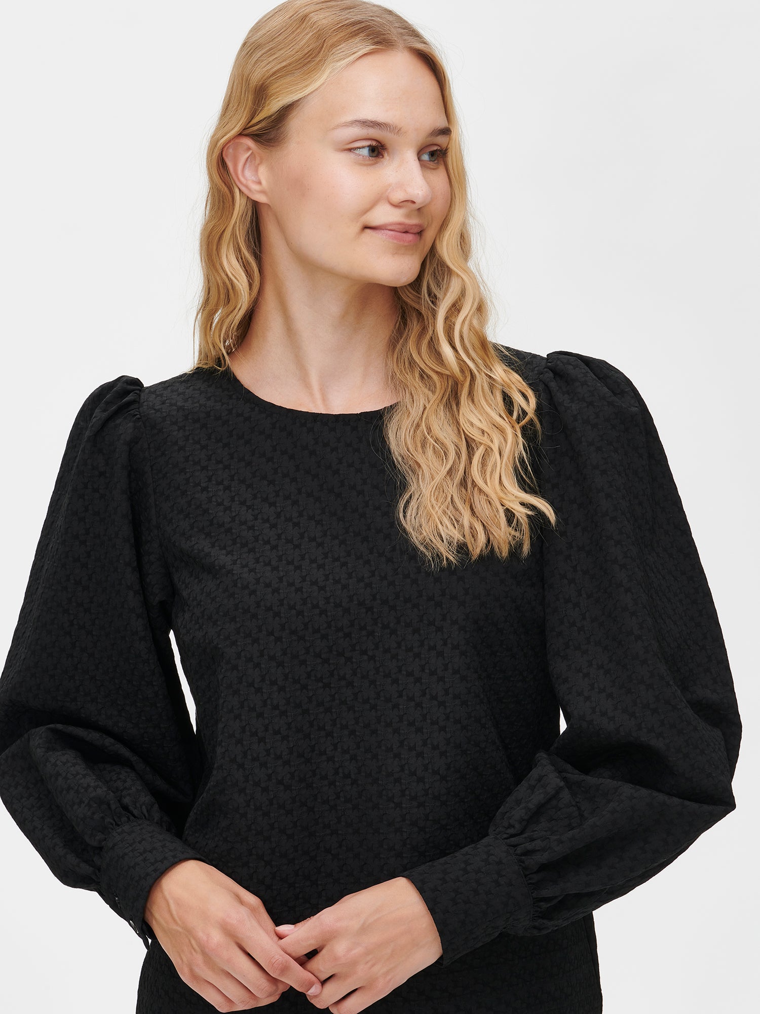 Nanso's stylish women's blouse in black features a beautiful textured surface. From the front close-up