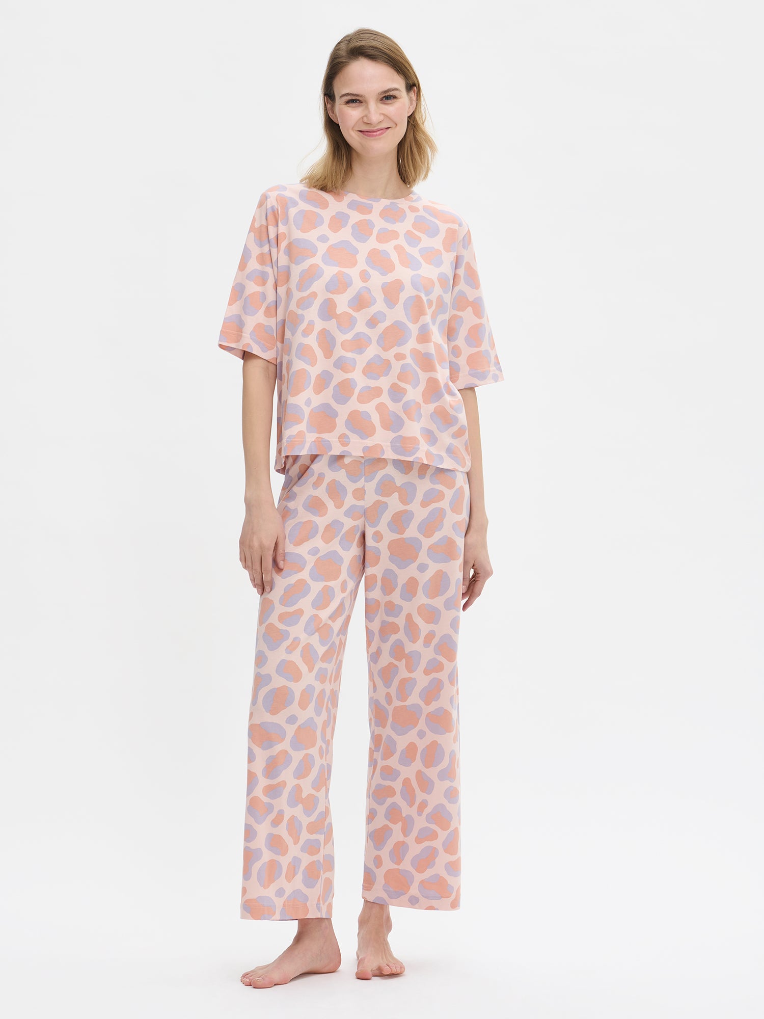 Nanso women’s patterned pink Pantteri trousers and matching top, worn by a model front view.