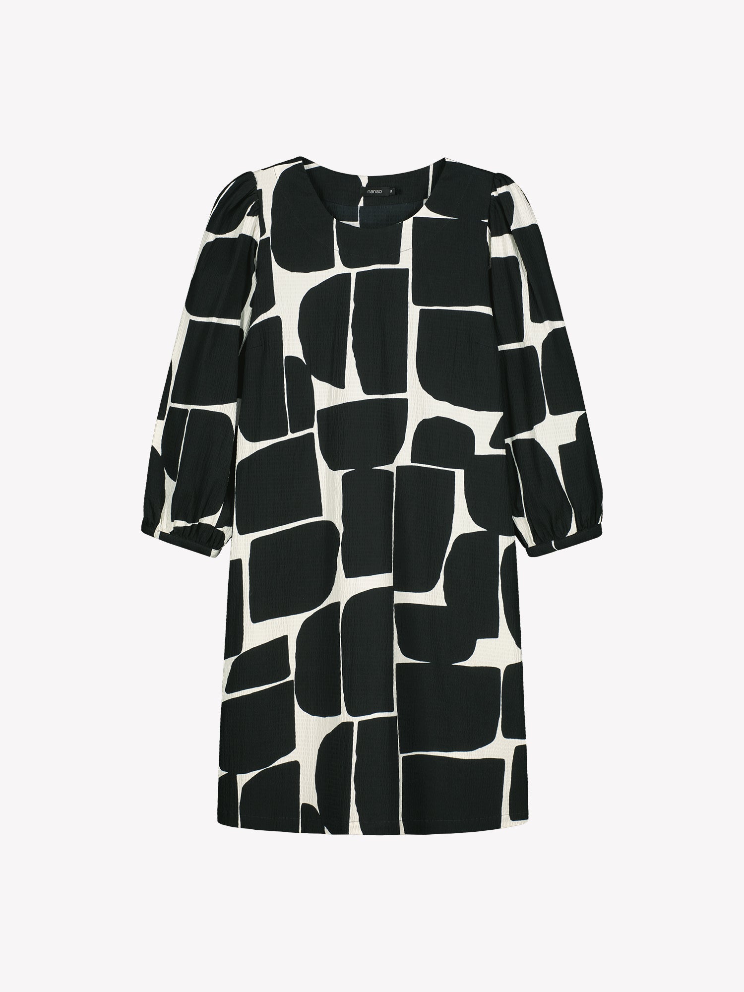 Nanso women’s black and white patterned Muuri dress in woven cotton, round neckline, gathered 3/4 sleeves and pockets, product photo front view.