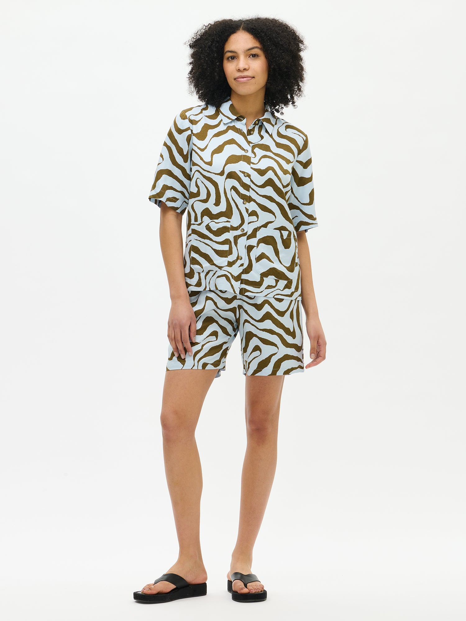 Nanso's Savanna shirt in light blue for women features a stylish pattern and short sleeves. From the front