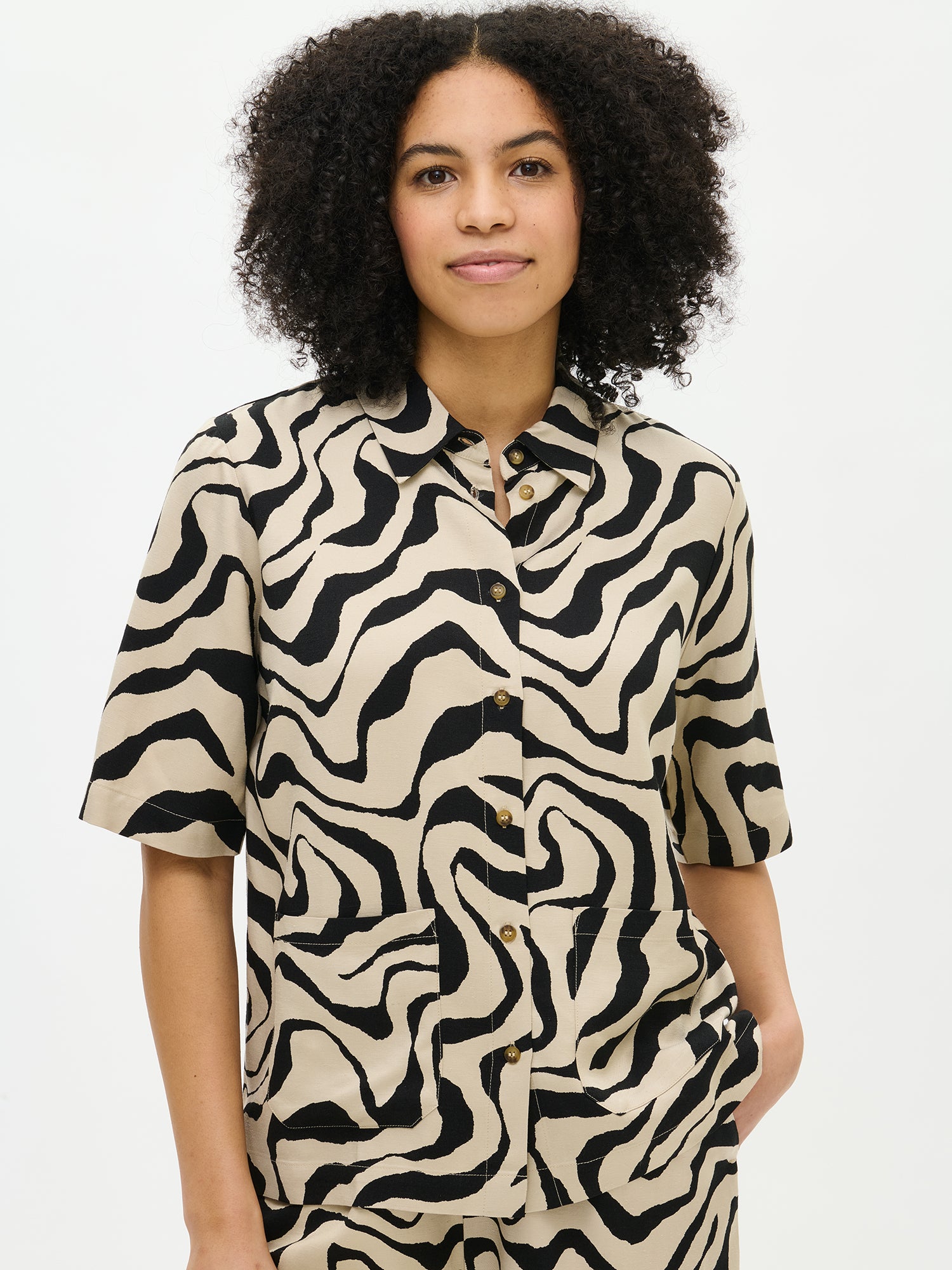 Nanso's Savanna shirt in beige for women features a stylish pattern and short sleeves, front