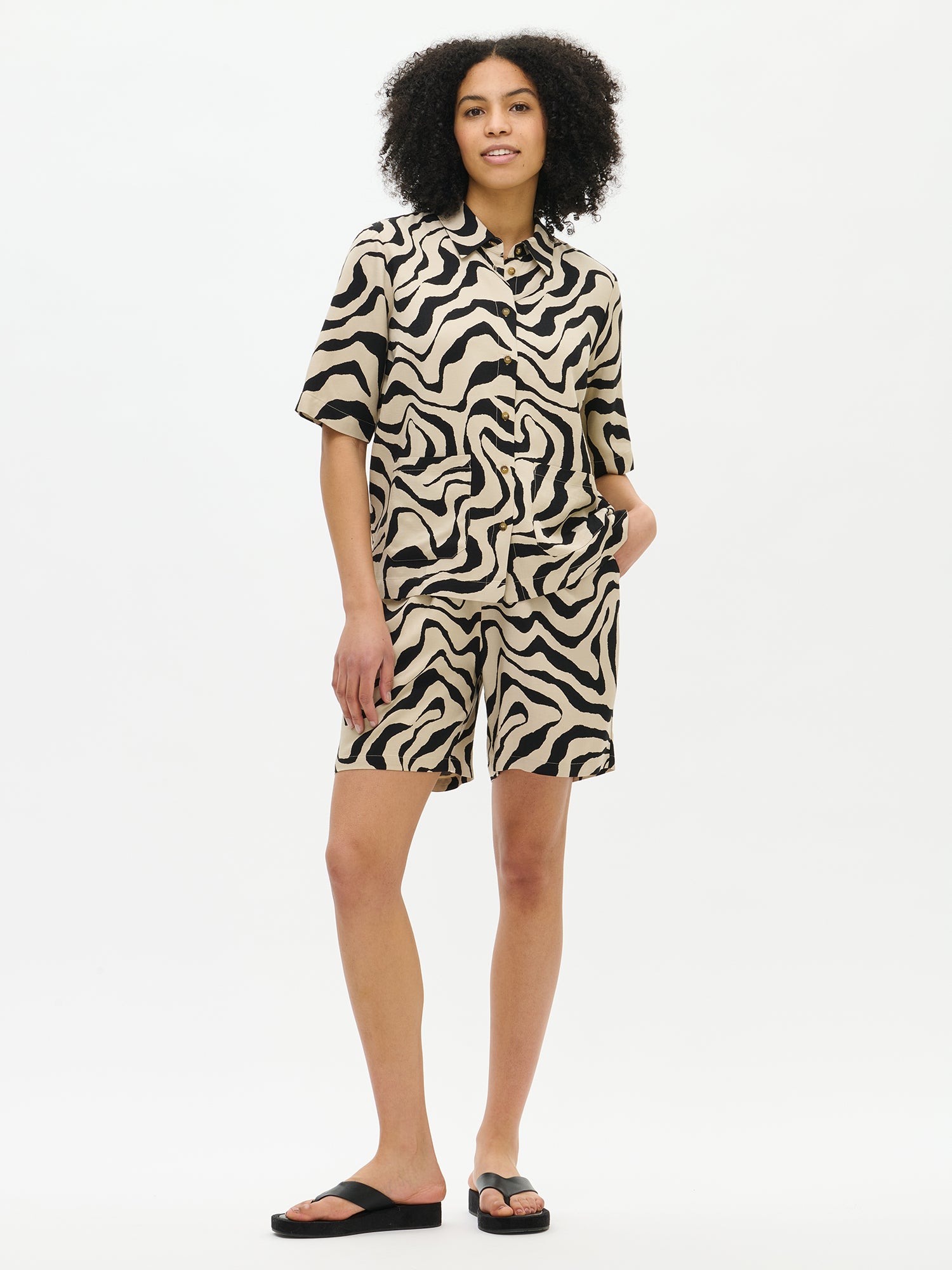 Nanso's Savanna shirt in beige for women features a stylish pattern and short sleeves, from the front