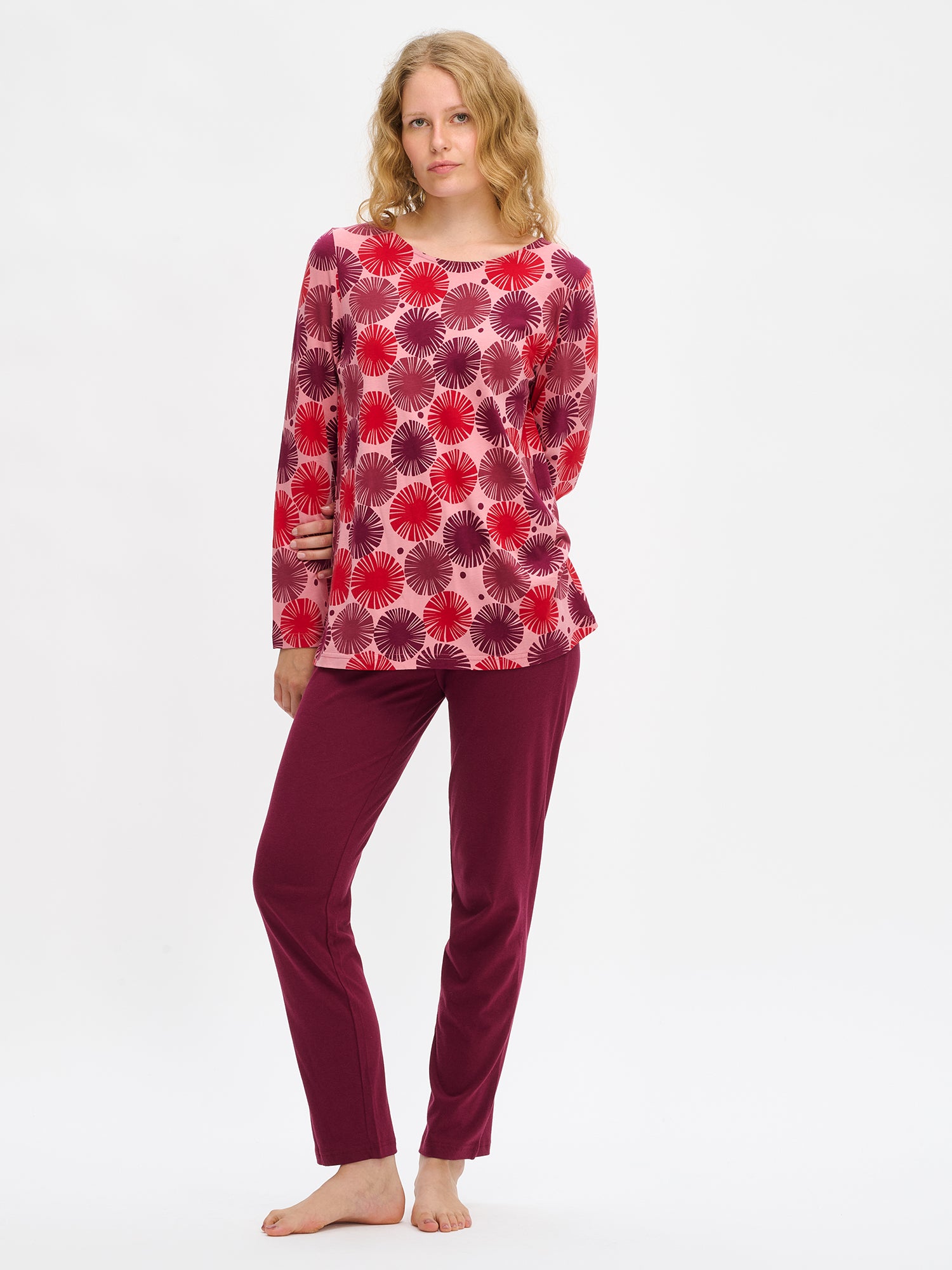 Nanso Amara red women’s pajama set with long-sleeved top in graphic print and solid full-length pants, worn by model.