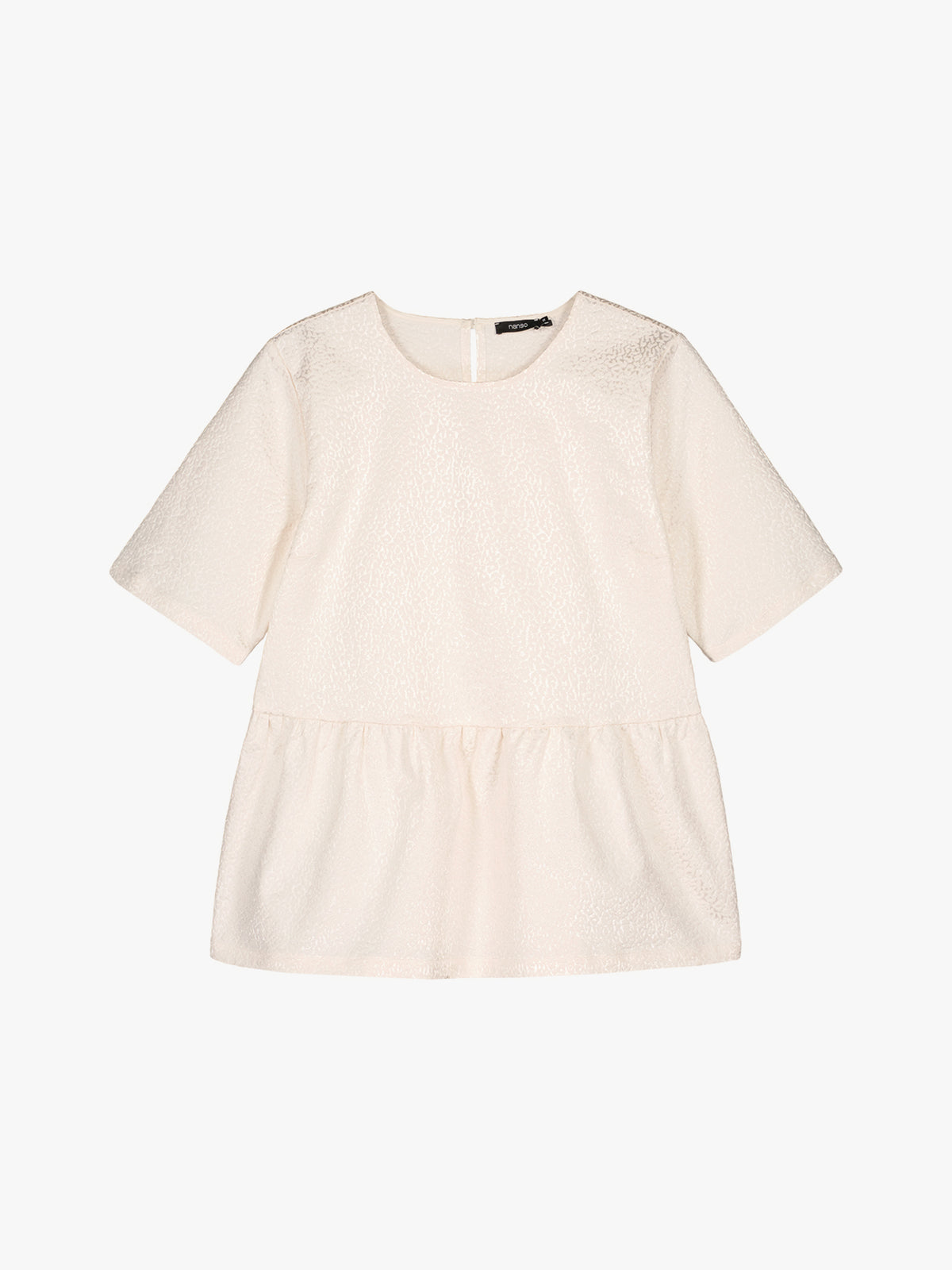 Nanso women's beautiful and elegant natural white Leora blouse captivates with its peplum-style silhouette and striking fabric, combining a subtle sheen with a richly textured surface. Product picture.