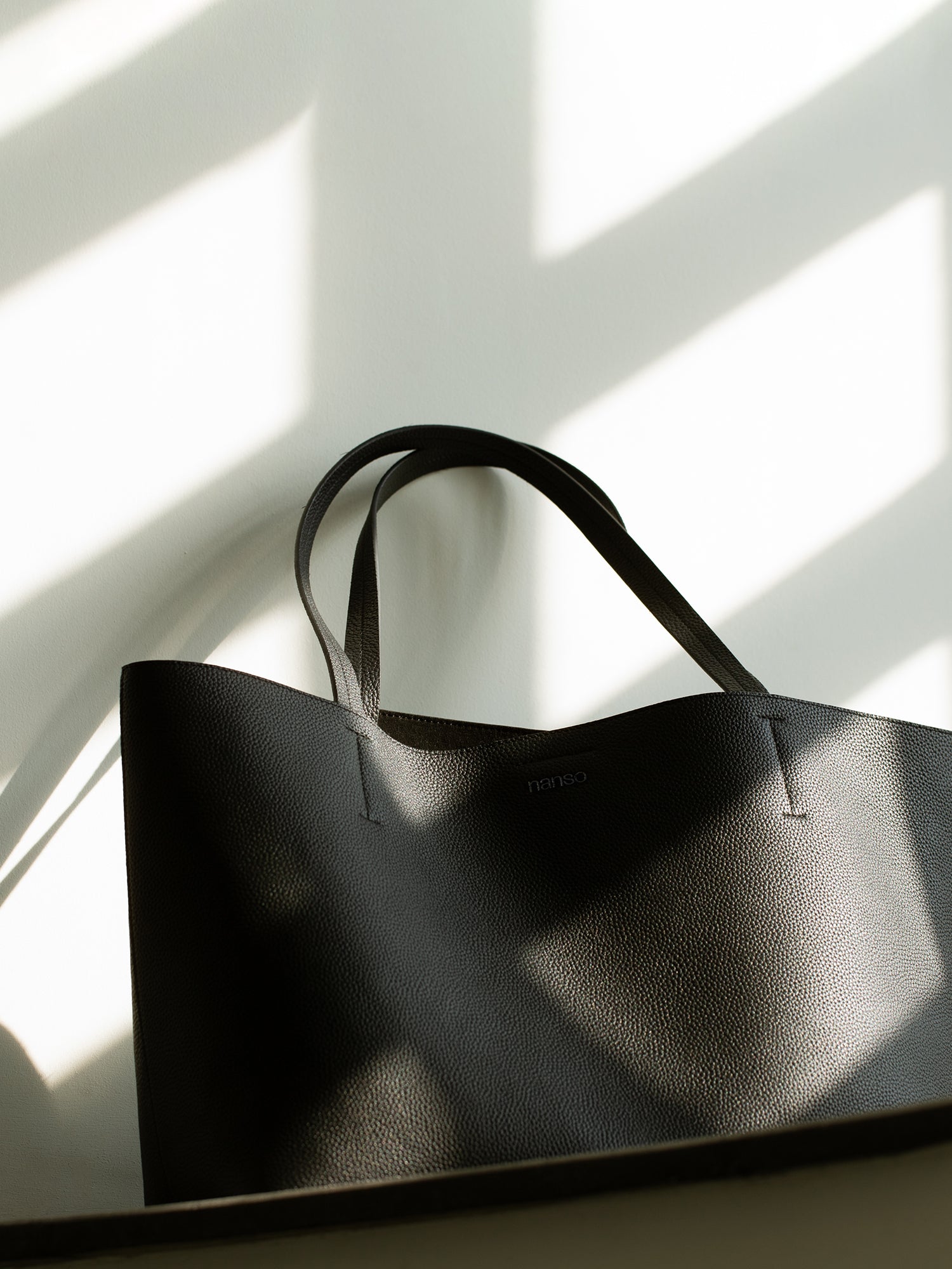 A stylish tote-style Maxi Naru leather bag in classic black, close-up