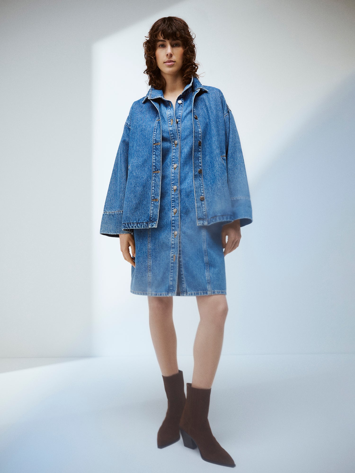 Nanso women's Doris denim dress and Doris Denim jacket on a model with brown suede boots.