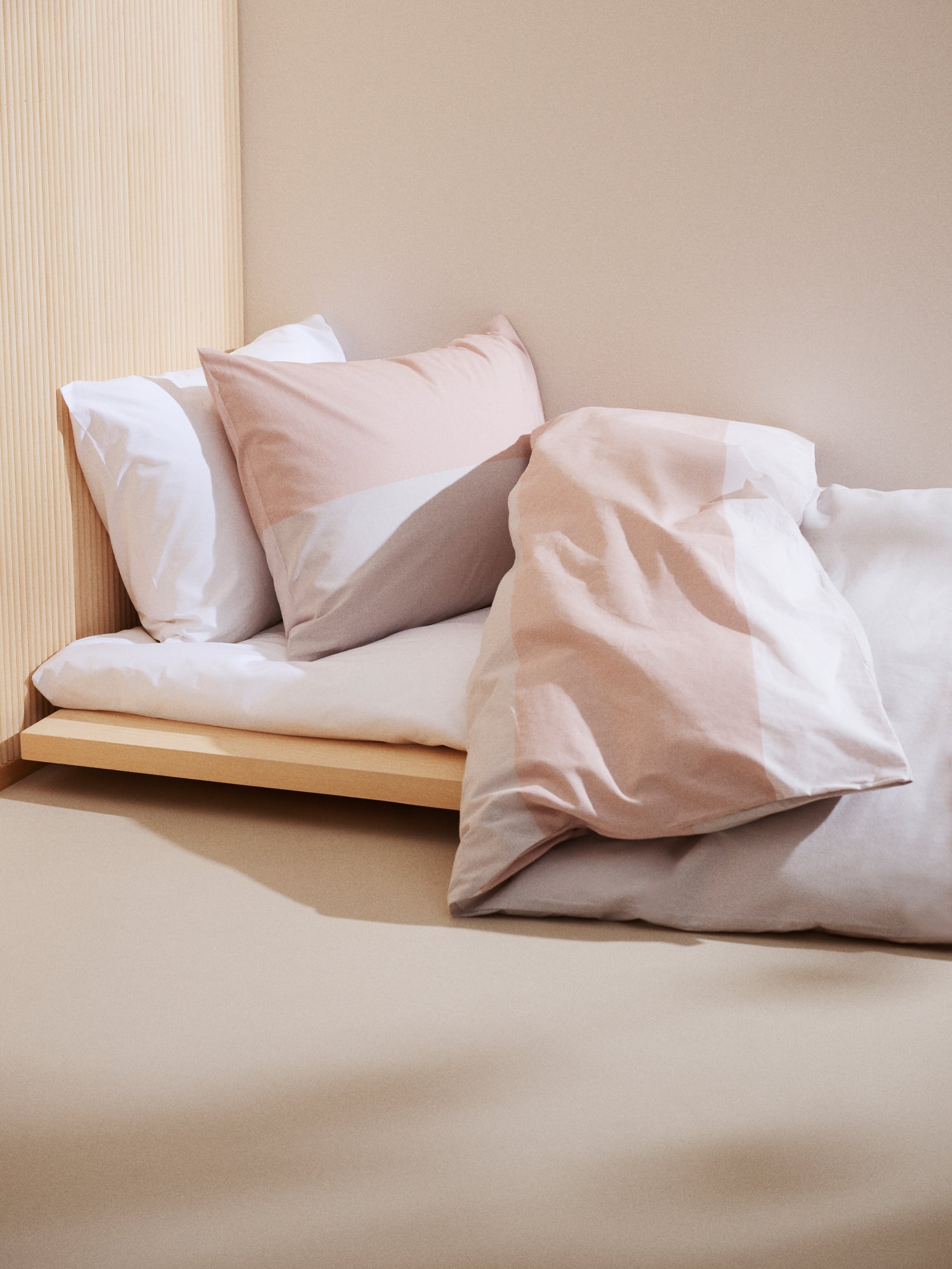 Nanso's beige Trio duvet cover set features a beautiful wide striped pattern, on a bed