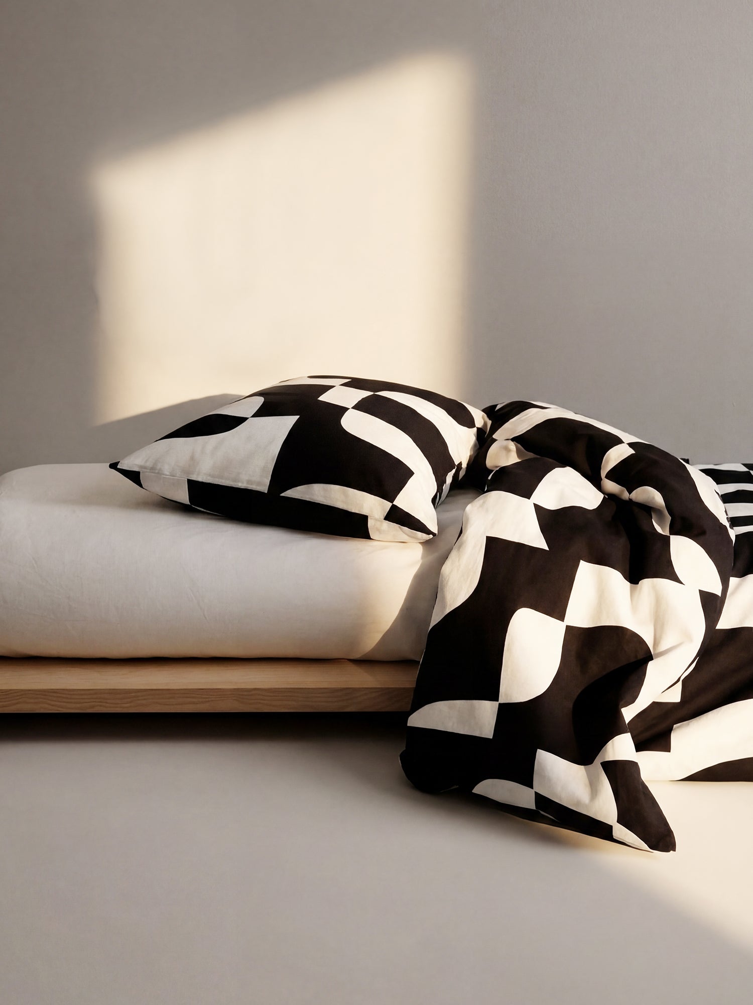 The Kallio Duvet Cover set brings understated elegance to your bedroom with its refined geometric pattern in soft beige and black tones, in a home decor picture