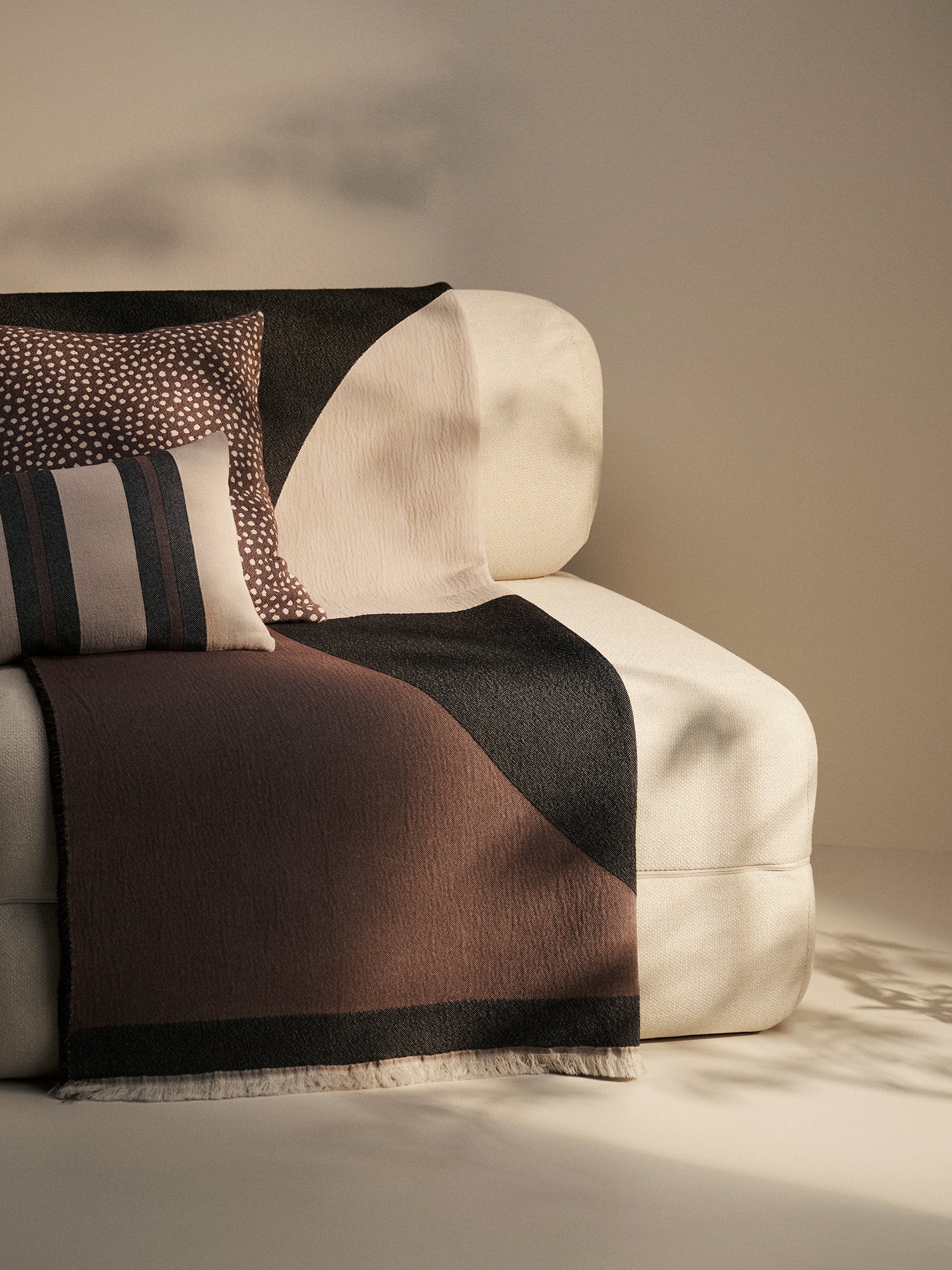Nanso beautiful Art blanket with a neutral toned stylish pattern woven using jacquard technique, pictured in a beautiful home decor setting with throw pillows.
