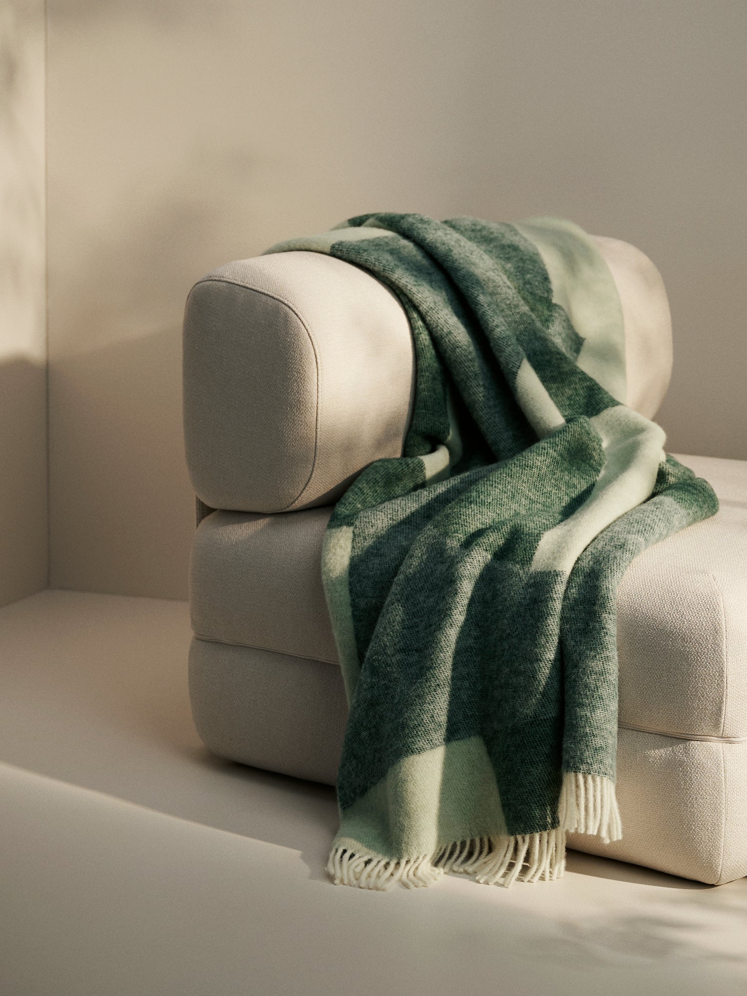 TAIDE Wool Blanket, crafted from 100% new, virgin wool in a stylish green toned design, in a cosy home decor picture