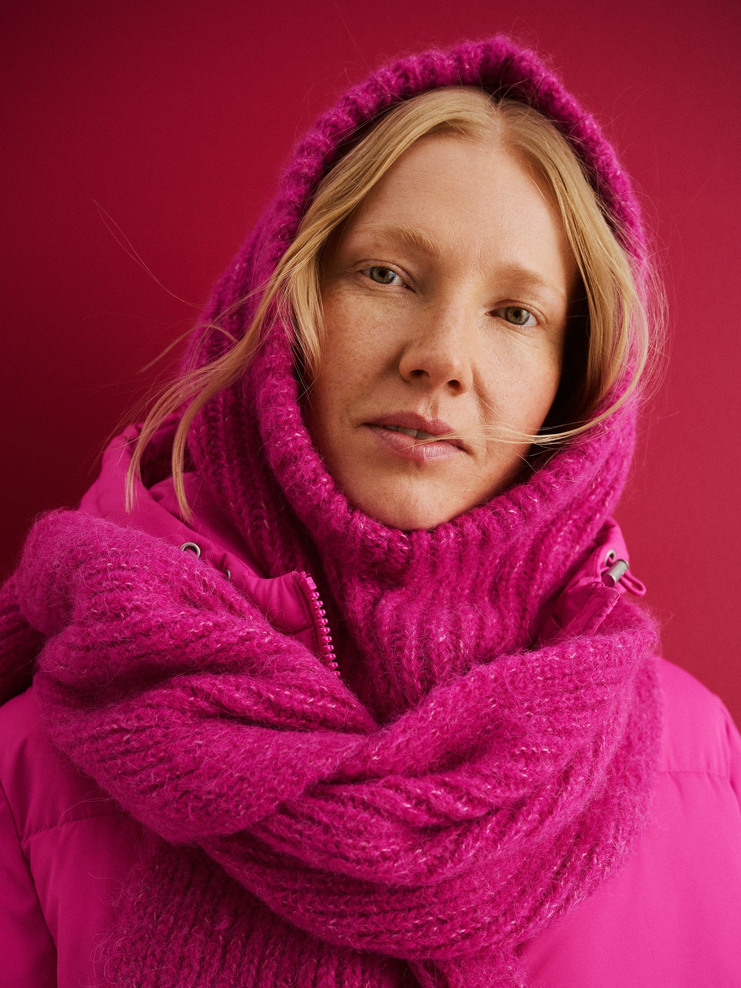 Nanso's soft and warm pink Usva scarf for women features a ribbed knit design., tied.