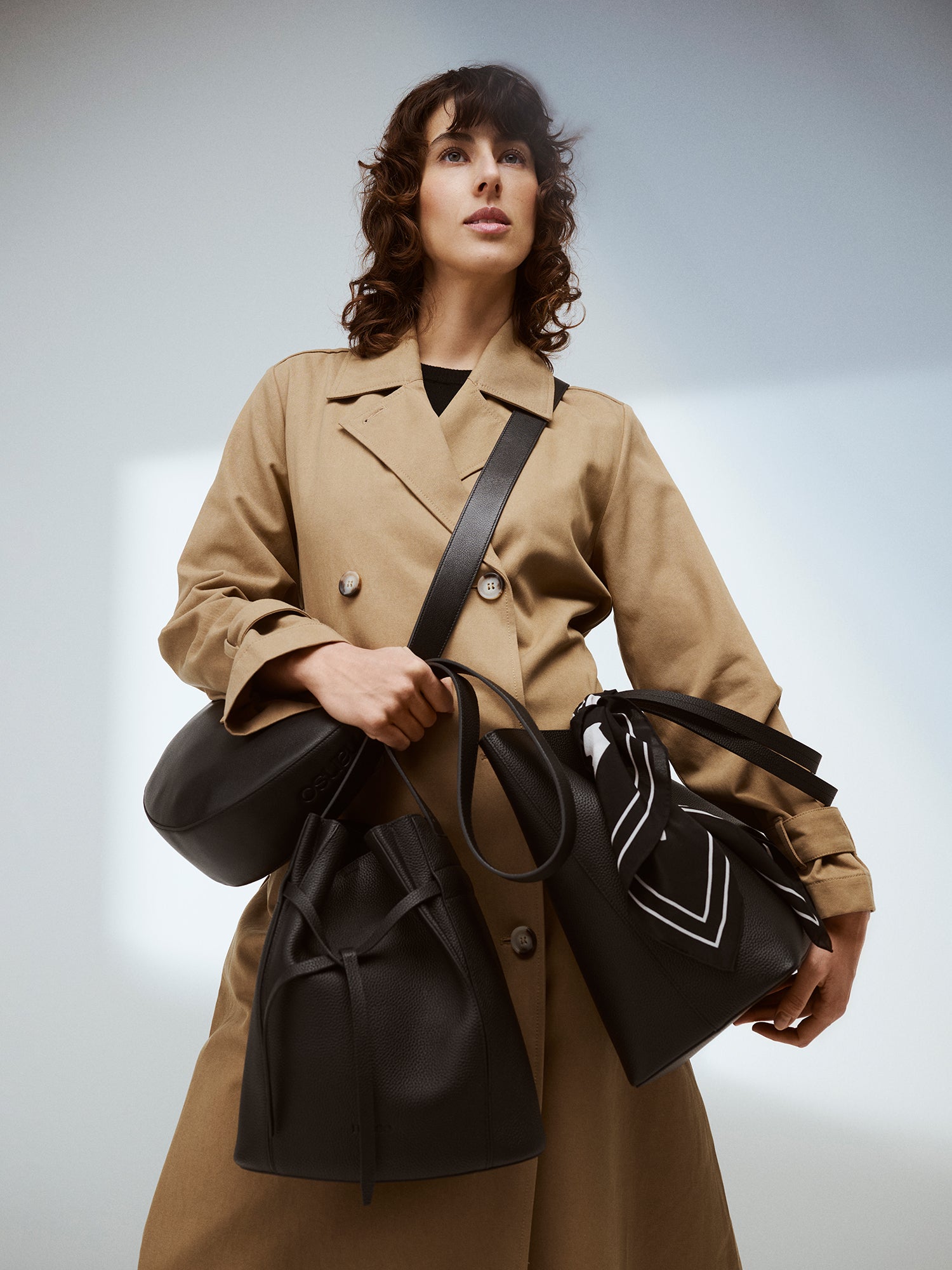 Brand picture with a model with Nanso leather bags and a trench coat.
