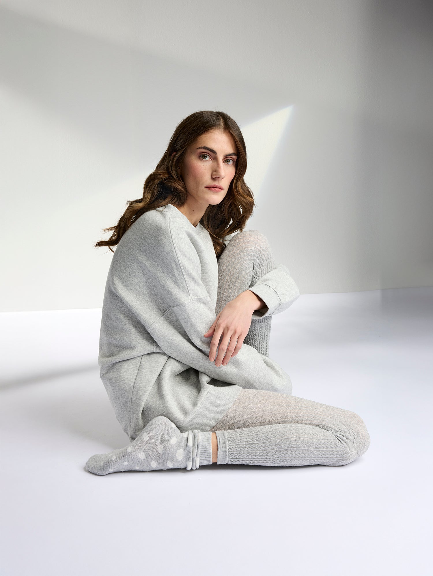 Vogue's soft cashmere-blend socks with a charming polka dot pattern on a model with a grey outfit
