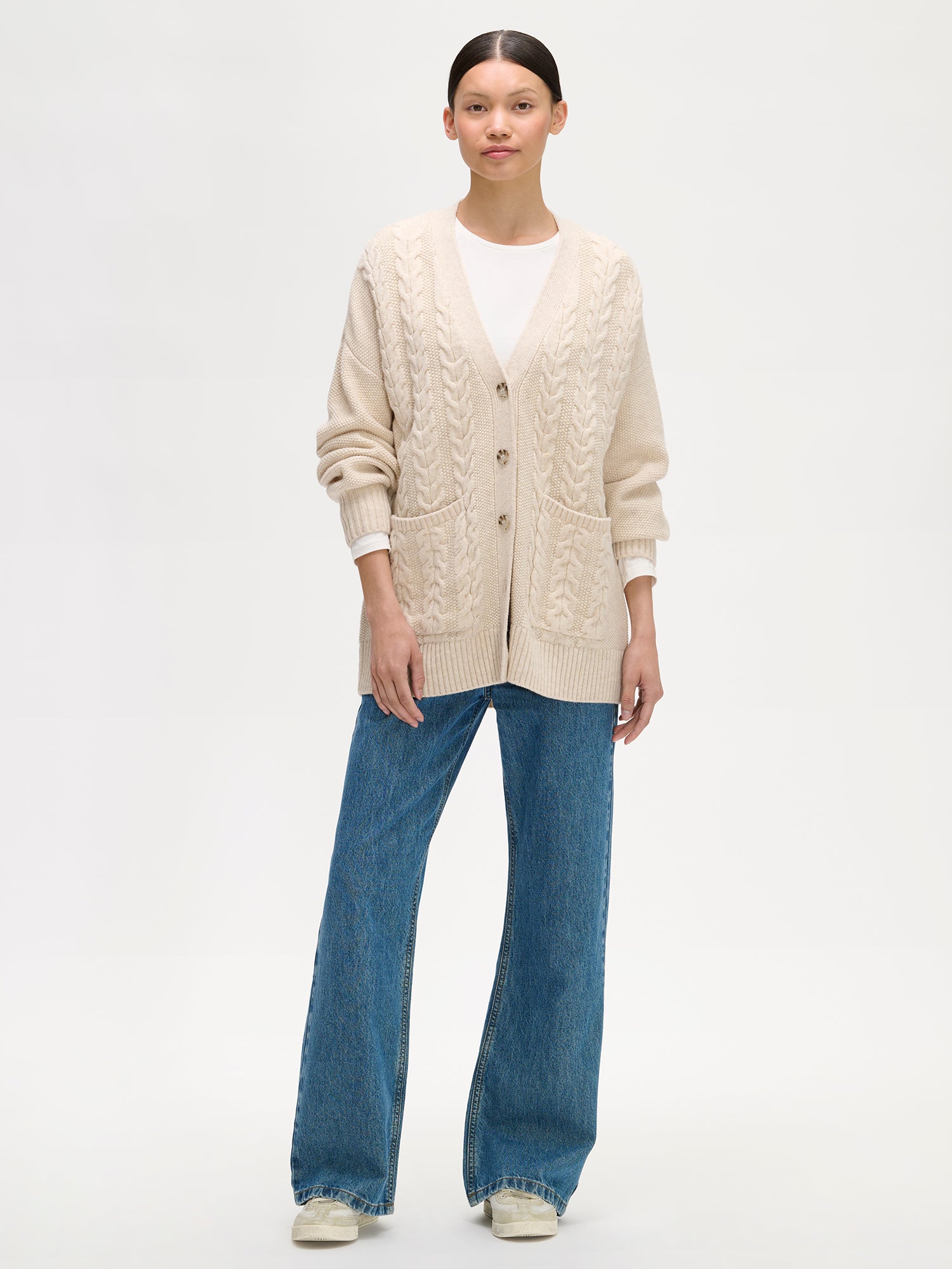 Video of beige cable knit worn by a woman