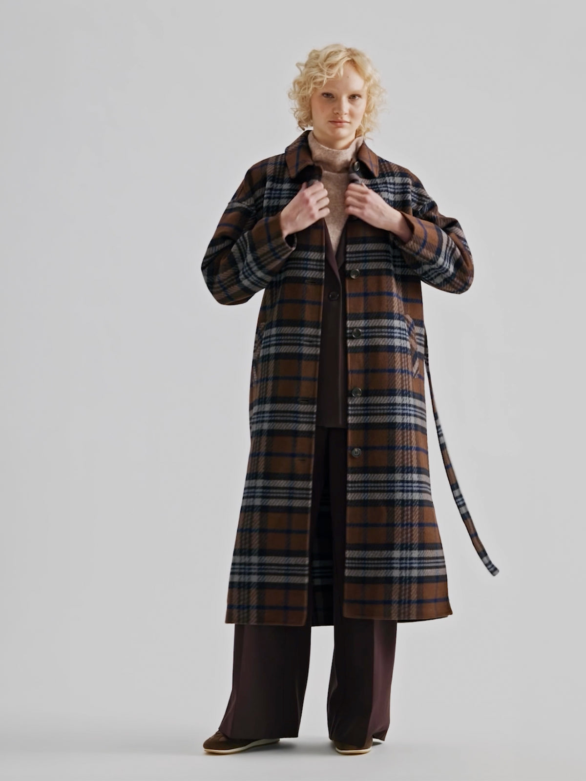 The stylish and timeless Astrid wool coat features a contemporary checked pattern, pictured on a model