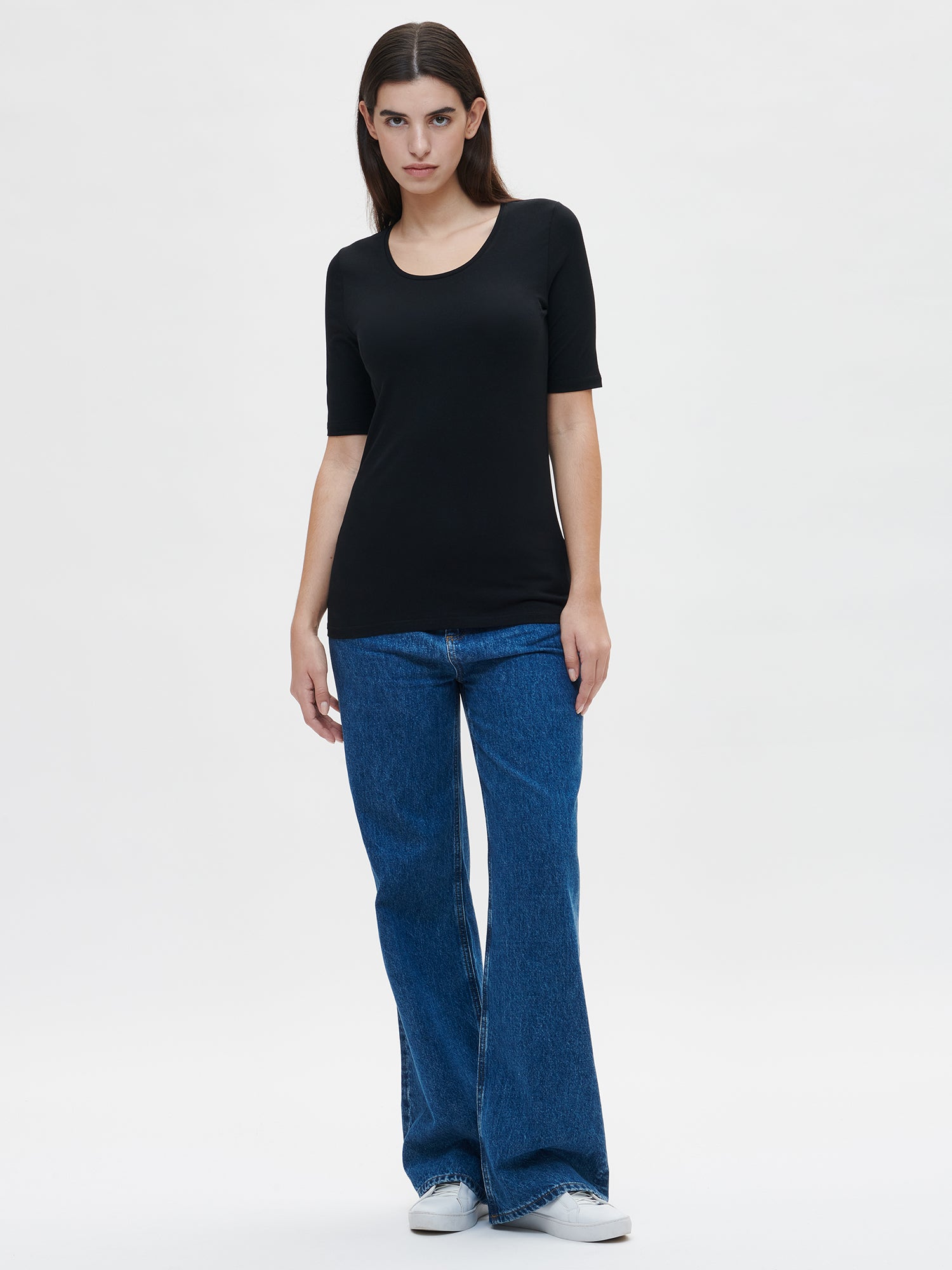 This versatile and stylish women's BASIC T-shirt in black is perfect for everyday wear. Its simple yet timeless design is suitable for any occasion. Worn by a model in size S.