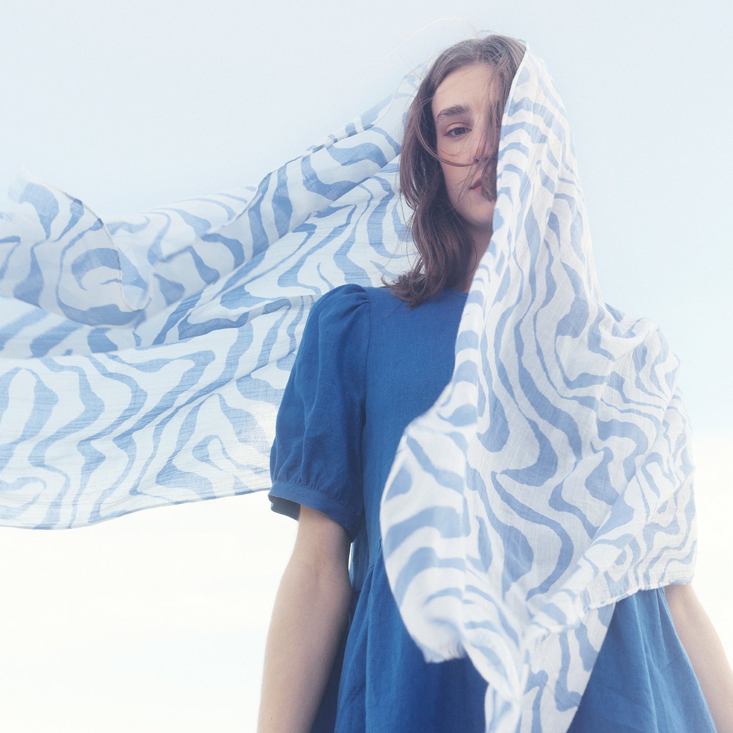 Nanso blue Sarastus linen dress and a scarf flying in the wind on a female model