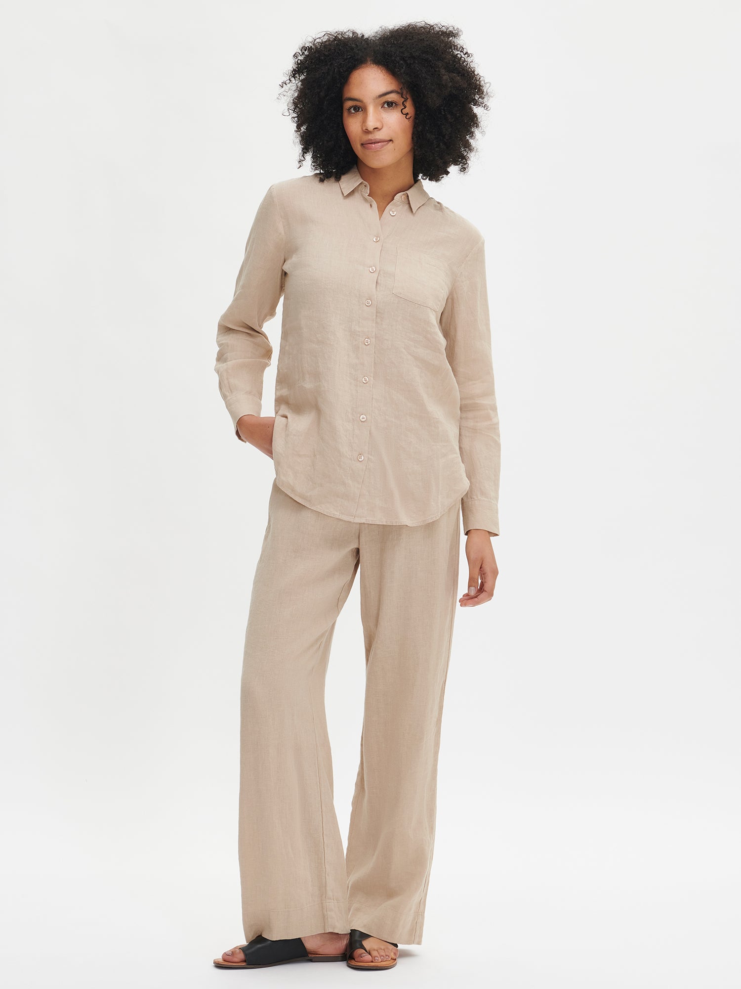 Nanso's Saari linen pants in beige are both stylish and timeless, perfect for any occasion. The comfortable pants feature an elastic waistband in the back and pockets on the sides. Worn by a model in size S from the front.