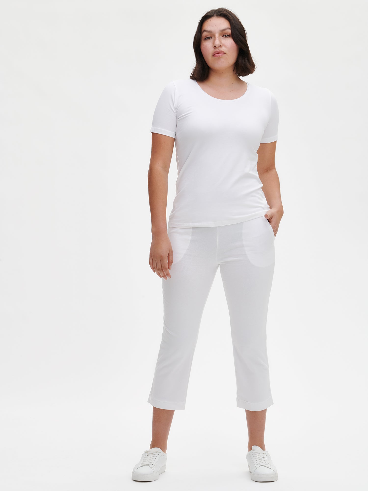 Women's Basic 7/8 jersey bottoms with a comfortable elastic band at the waist, side pockets and small side slits at leg openings. On a model from the front with white T-shirt.