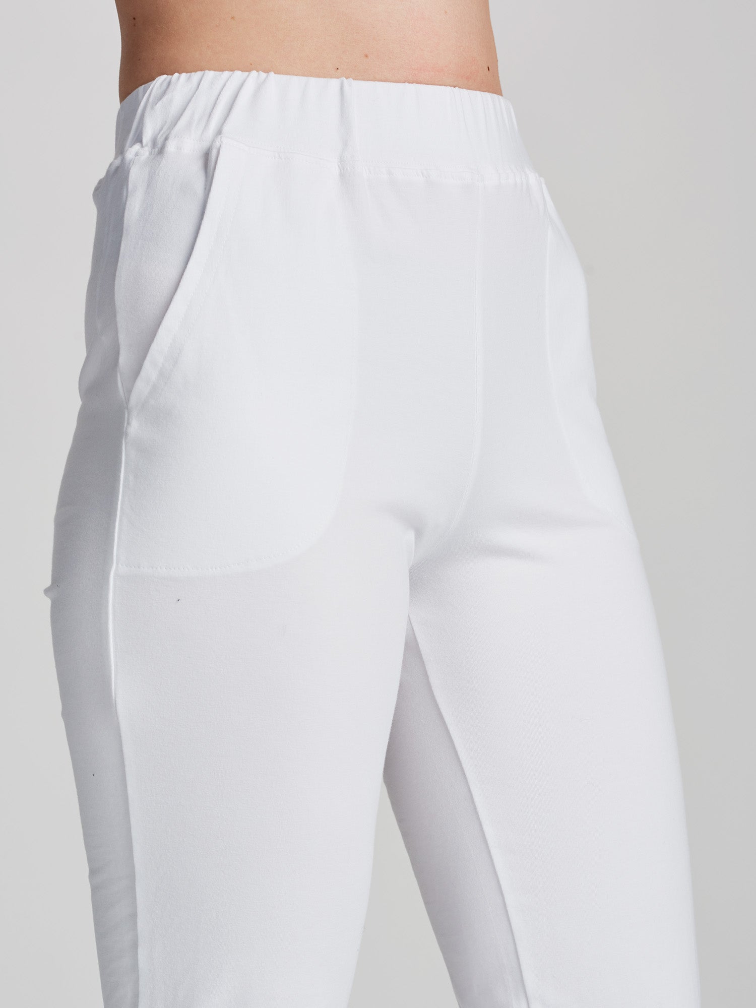 Women's Basic 7/8 jersey bottoms with a comfortable elastic band at the waist, side pockets and small side slits at leg openings. On a model pictured from the front, close-up.