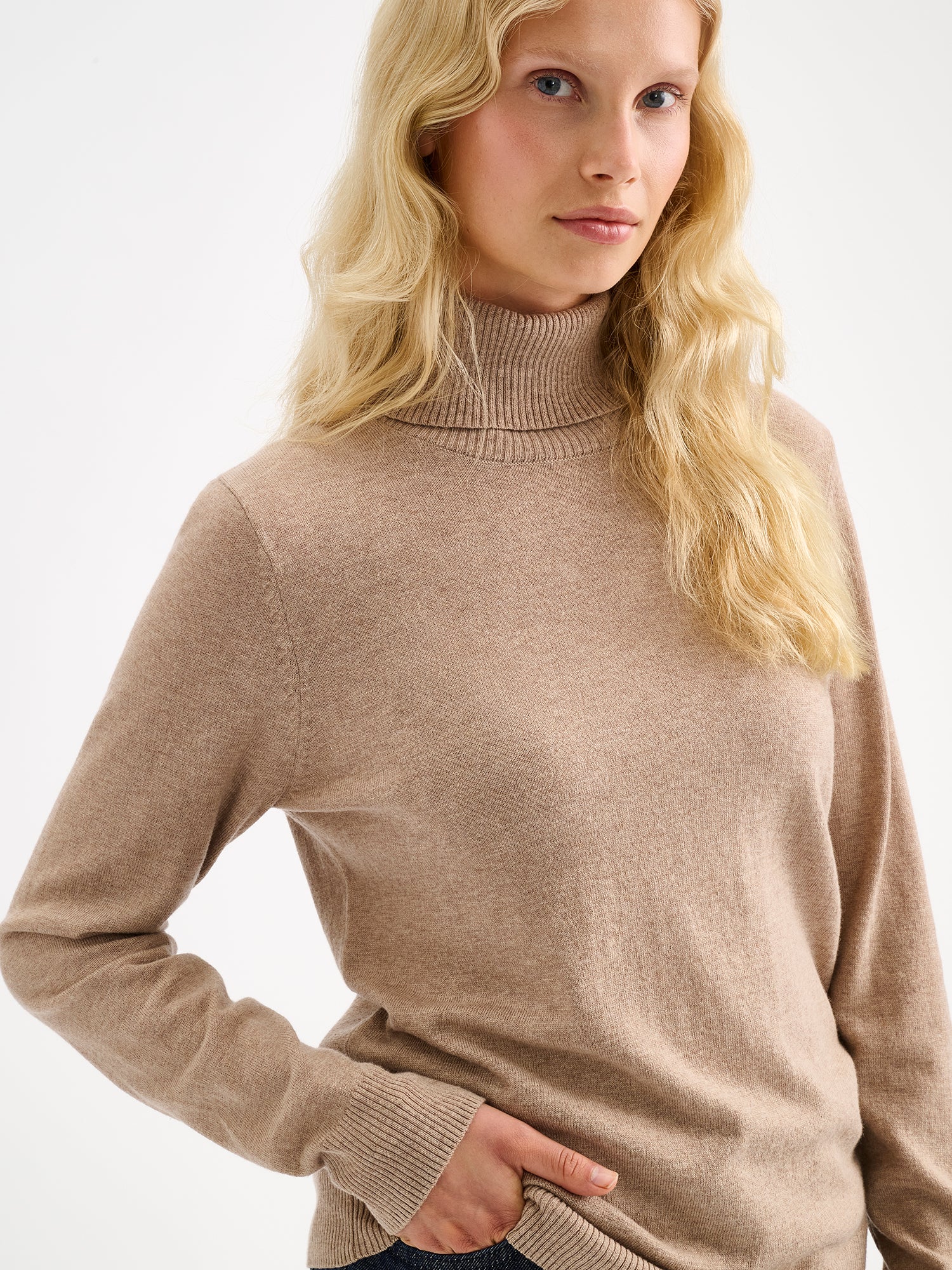 Nanso women’s stylish and lightweight beige Villis turtleneck sweater on a model close-up.