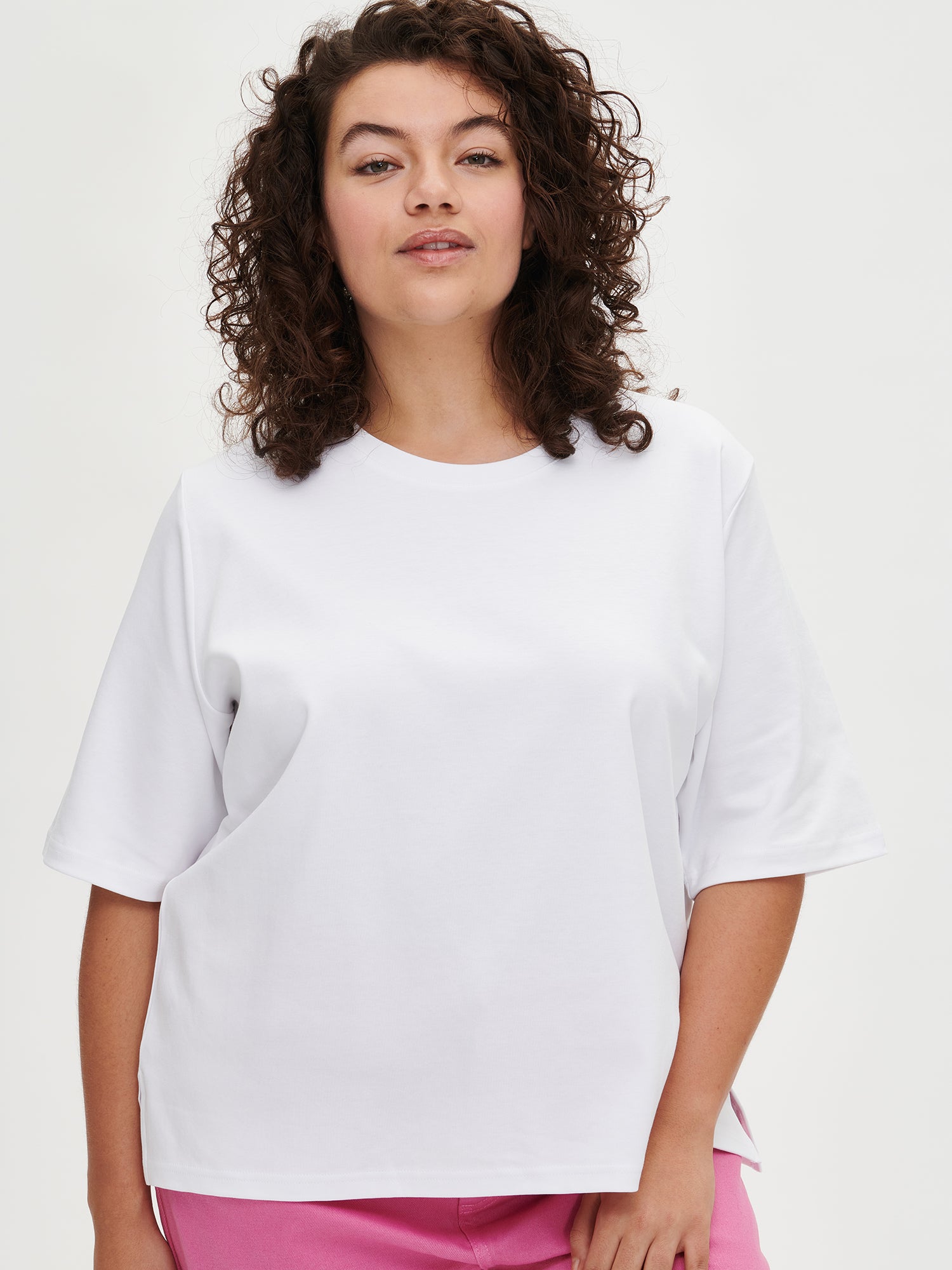 Nanso women’s white loose fit T-shirt from 100 % cotton, on a model in size XL, close-up.
