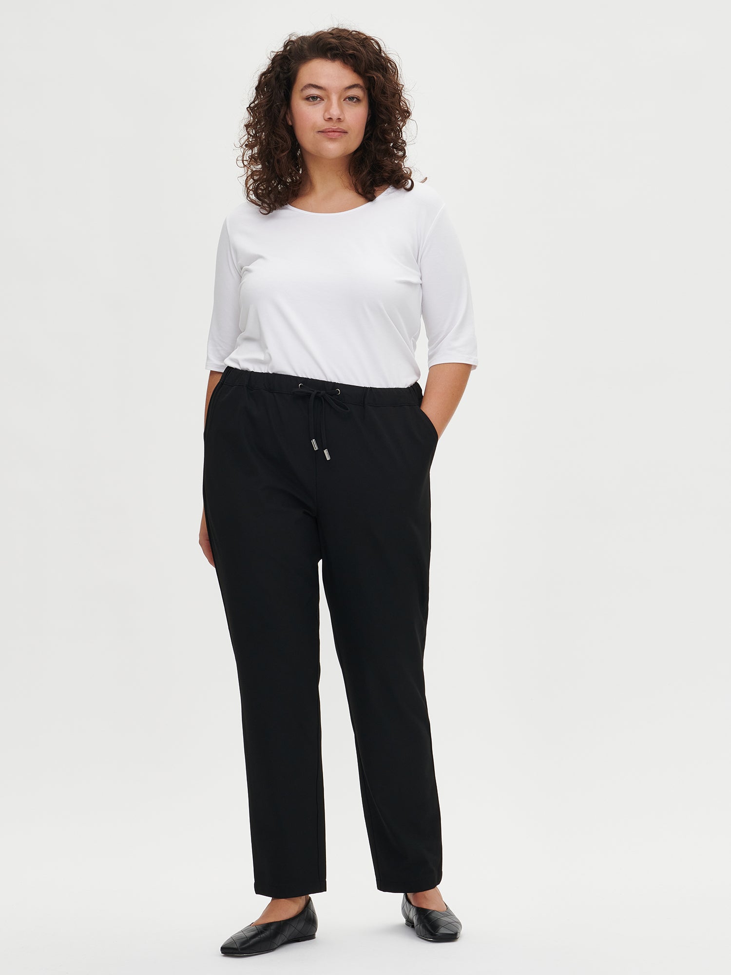 Nanso women's black Joggeri trousers with pockets and elastic waistband, on a model in size XL.