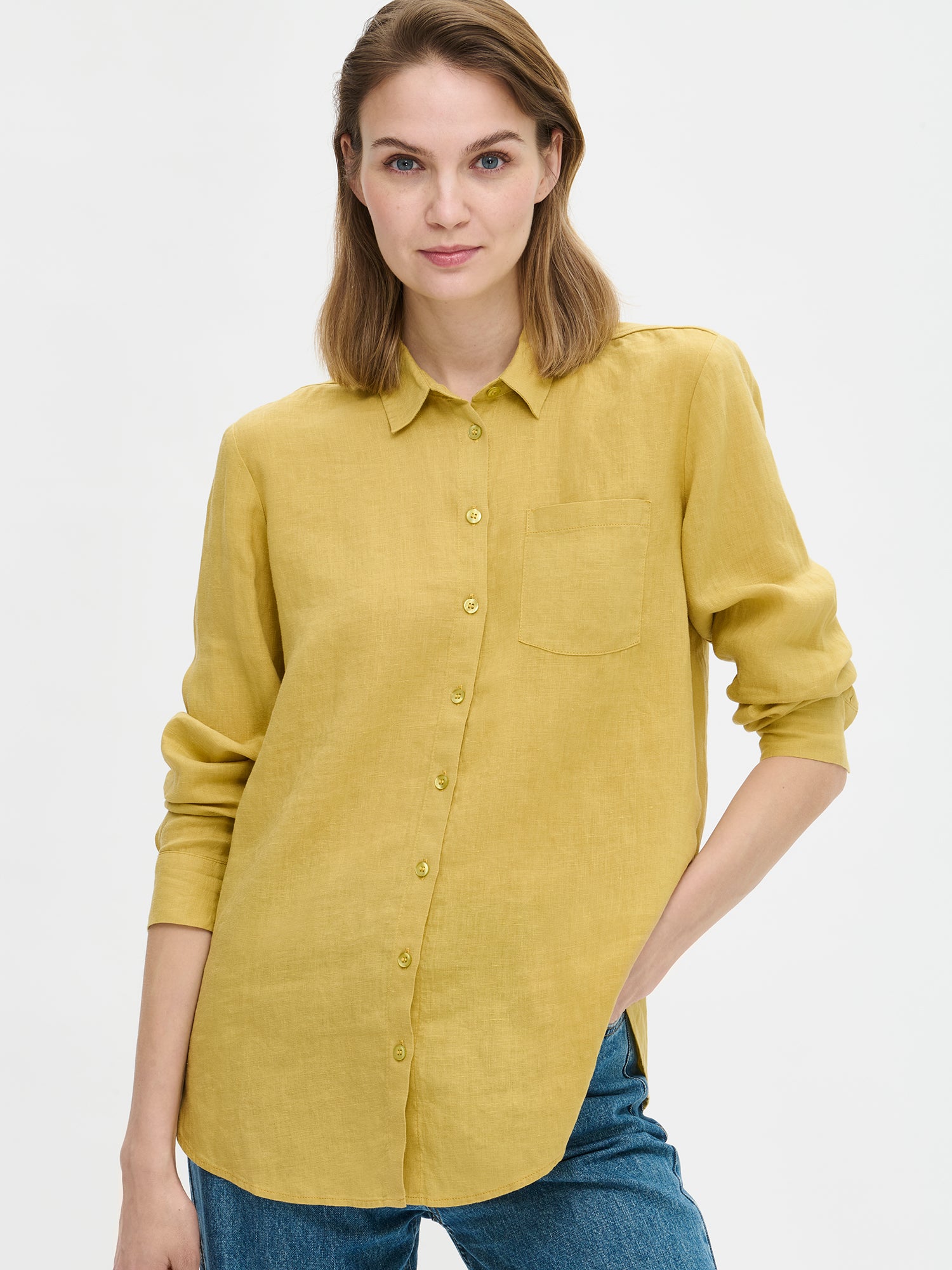 The classic, timeless PELLAVA Linen Shirt in yellow on a model with blue jeans, close-up.