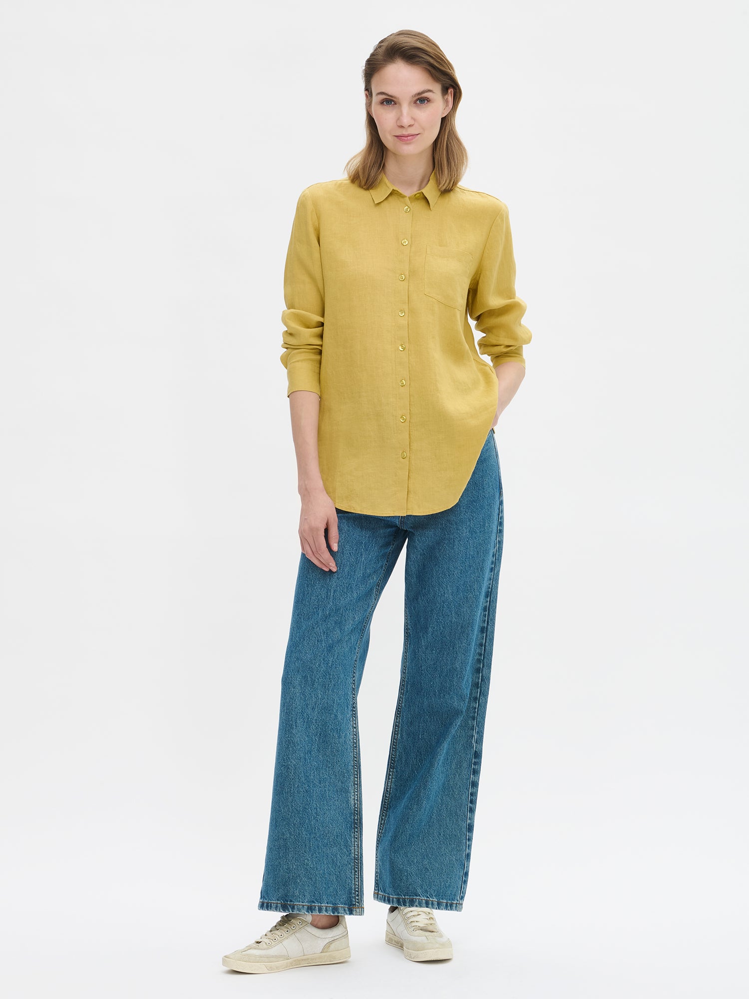 The classic, timeless PELLAVA Linen Shirt in yellow on a model with blue jeans.