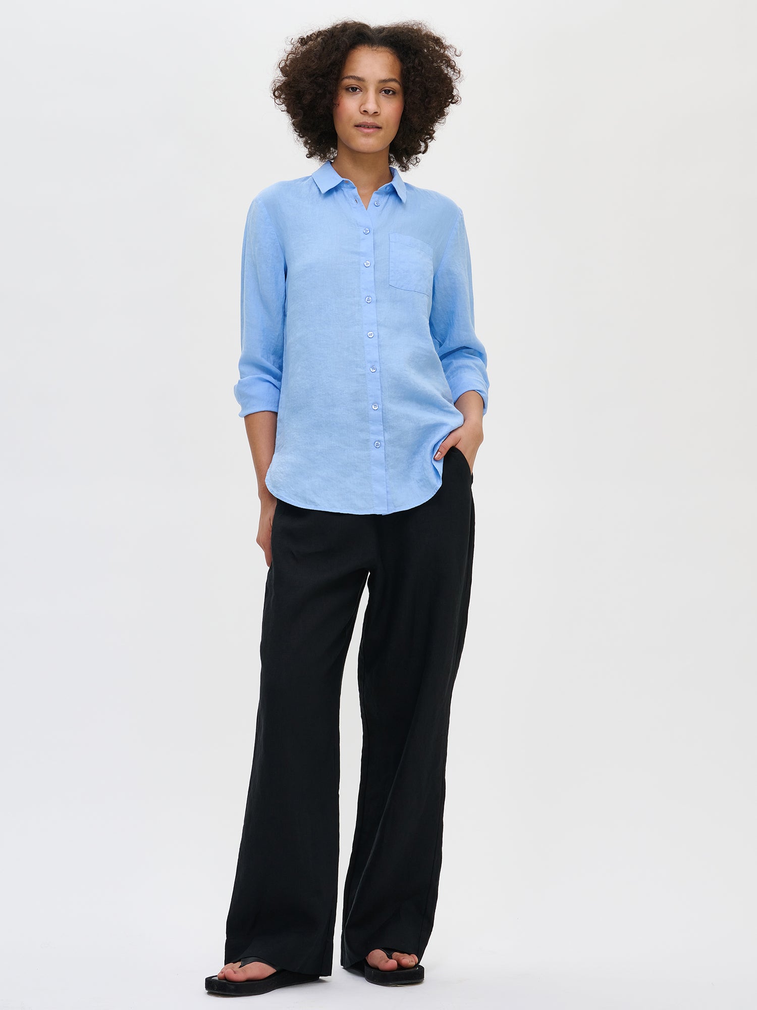 Women's classic long-sleeved blue linen shirt is a timeless piece that is essential in any wardrobe. Made of woven linen fabric, it is both durable and breathable, with a natural tendency to wrinkle. 