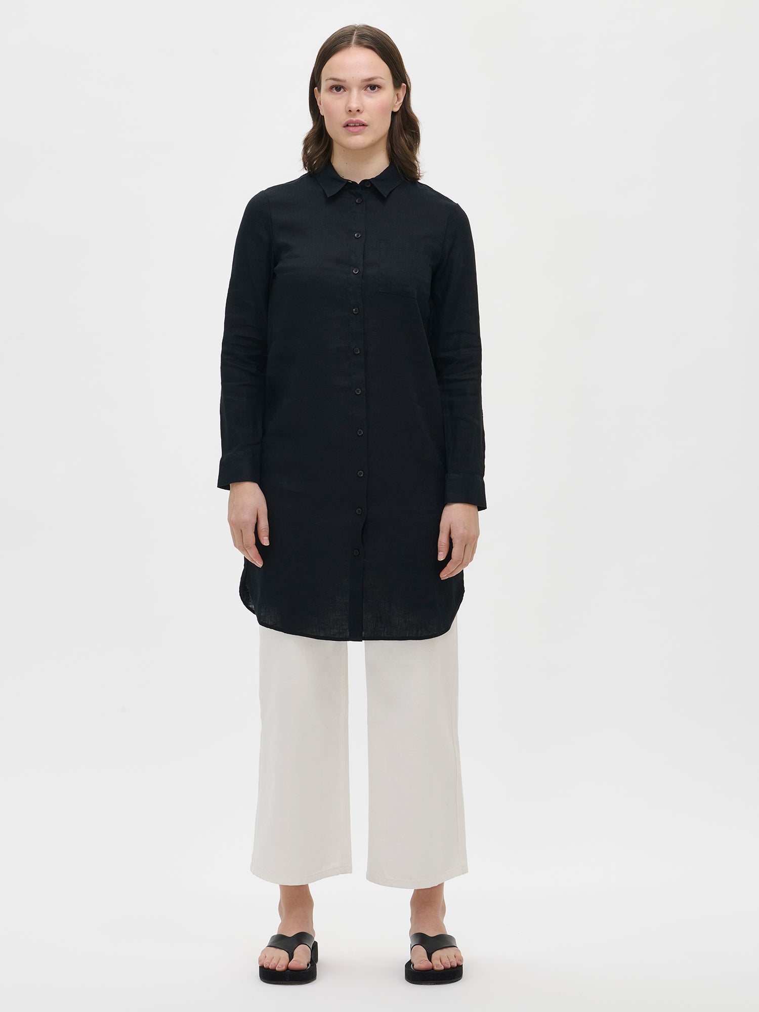 This lightweight and long PELLAVA linen shirt for women in black is perfect for both everyday wear and special occasions. Worn by a model in size S.
