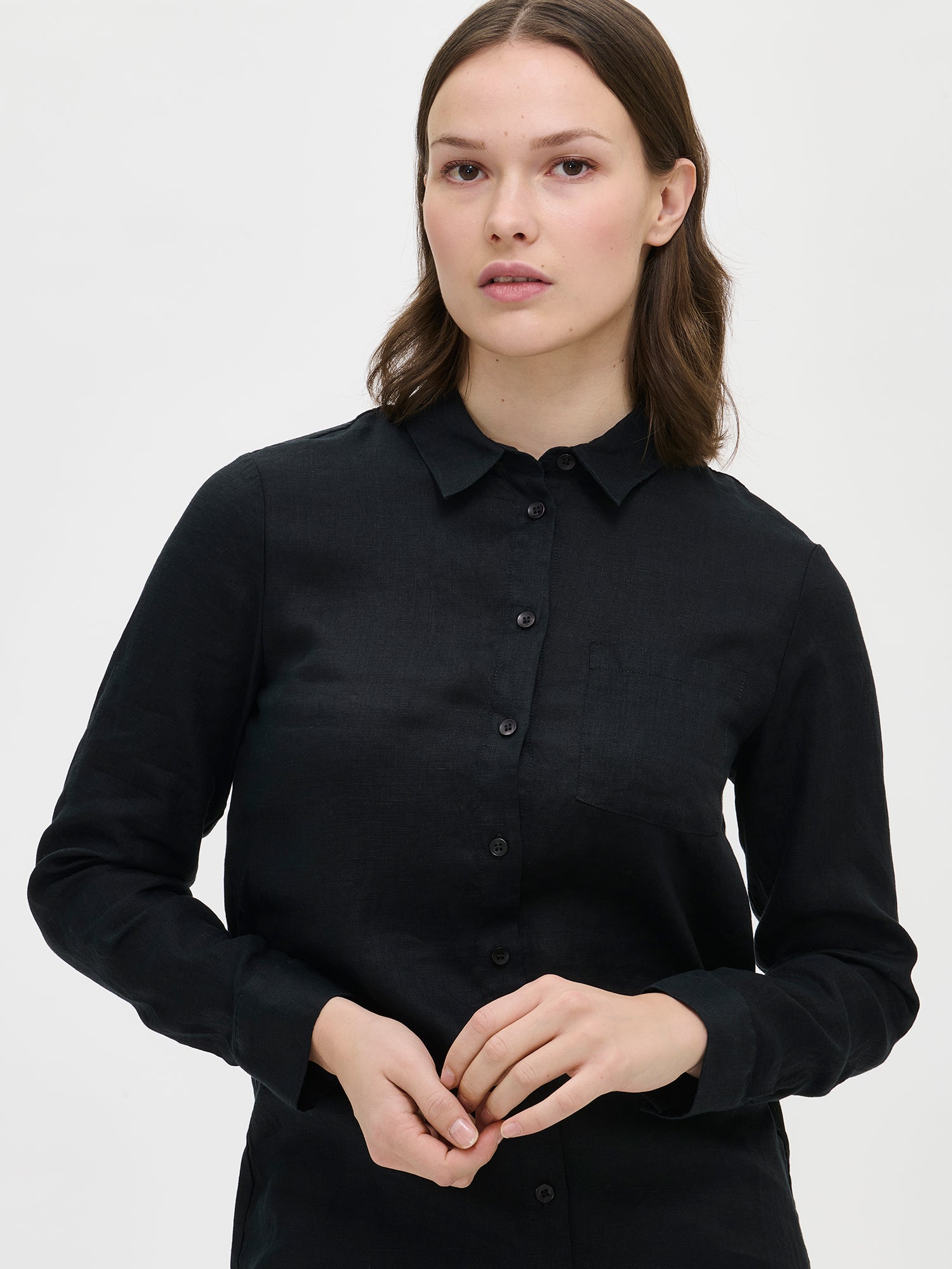 This lightweight and long PELLAVA linen shirt for women in black is perfect for both everyday wear and special occasions. Worn by a model in size S.