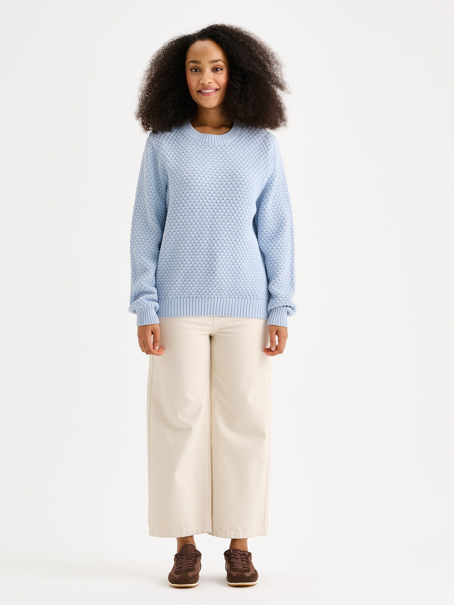 Women's KUMPU Knit Sweater in light blue on a model with light jeans